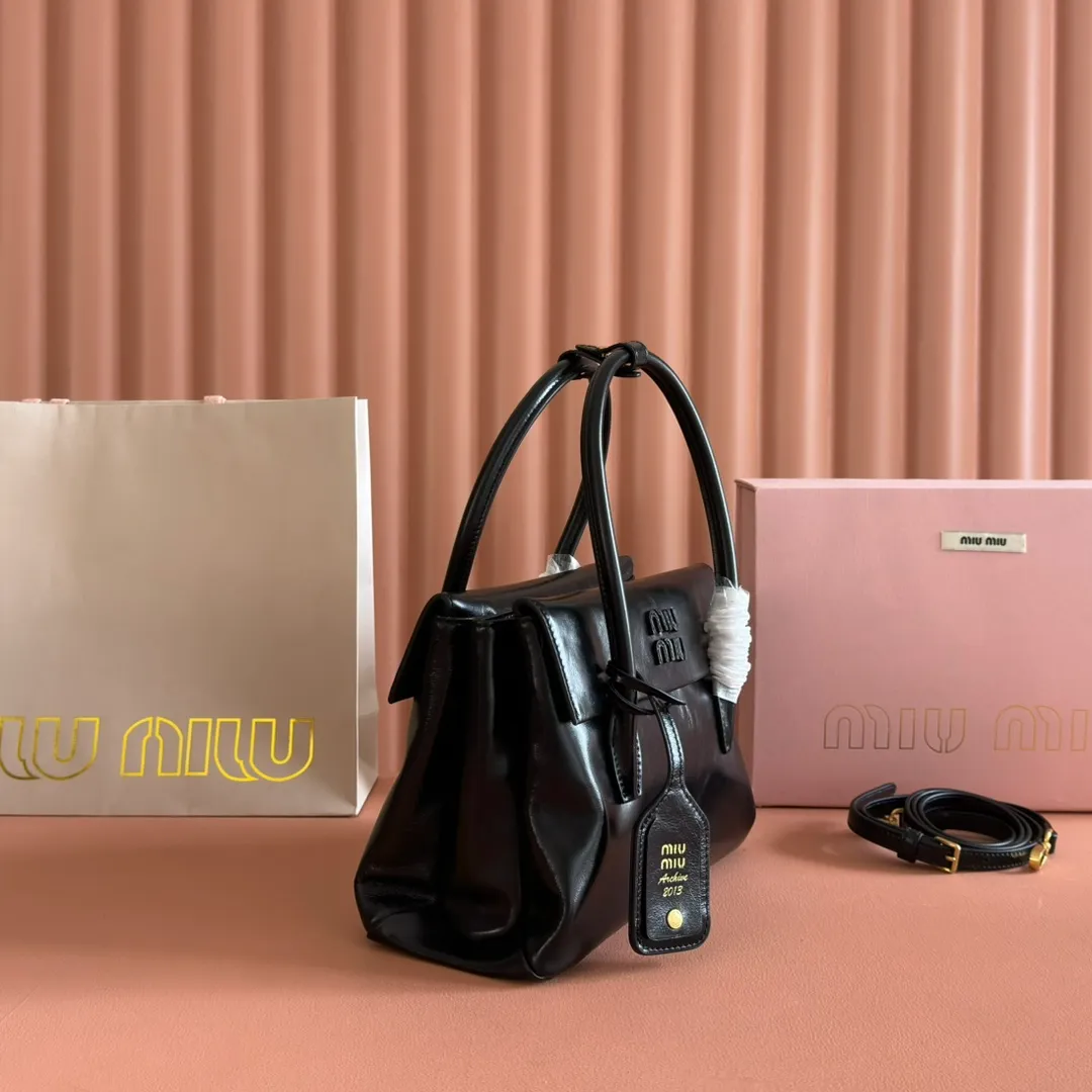 p1660💋💋💋【Configure full counter package】Solitaire Small Handbag in Glossy Leather: 5BA301 Structured lines and exquisite details define this handbag, inspired by MiuMiu’s 2006 archives. An elegant style that combines classic and experimental is enhanced by the iconic logo on the front and a shiny finish. ·With handles ·Front and back pockets ·Golden hardware ·With zipper pocket and patch pockets ●Front lettering logo Width: 25cm, Height: 18cm, Length: 10cm?