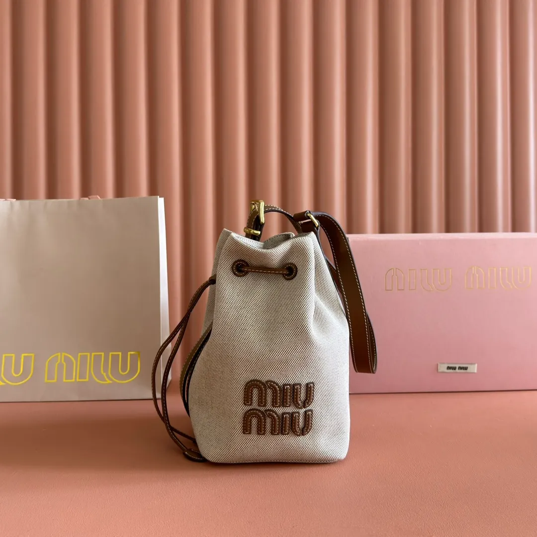 p1300💋💋💋【Full set of packaging at the counter】5BE089 Canvas Bucket Bag This canvas and leather bucket bag from Miu family is intertwined with contrasting materials and colors, highlighting its unique design features. The letter logo adds a unique personality to the design of this bag. Adjustable leather handles Gold-plated hardware Leather letter logo on front Leather drawstring closure Linen fabric lining Model: 5BE090 Dimensions: Height 16cm Width 22.5cm Length 14cm