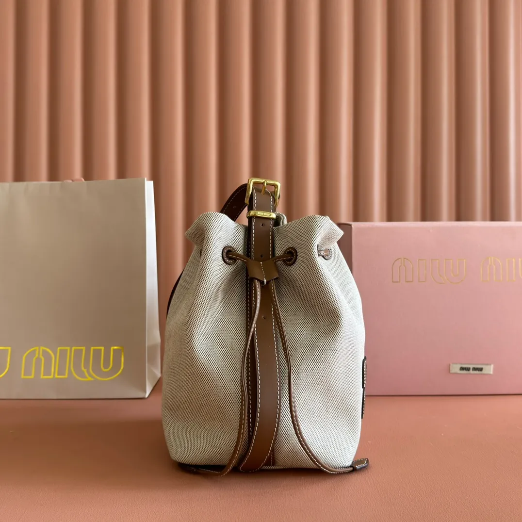 p1300💋💋💋【Full set of packaging at the counter】5BE089 Canvas Bucket Bag This canvas and leather bucket bag from Miu family is intertwined with contrasting materials and colors, highlighting its unique design features. The letter logo adds a unique personality to the design of this bag. Adjustable leather handles Gold-plated hardware Leather letter logo on front Leather drawstring closure Linen fabric lining Model: 5BE090 Dimensions: Height 16cm Width 22.5cm Length 14cm