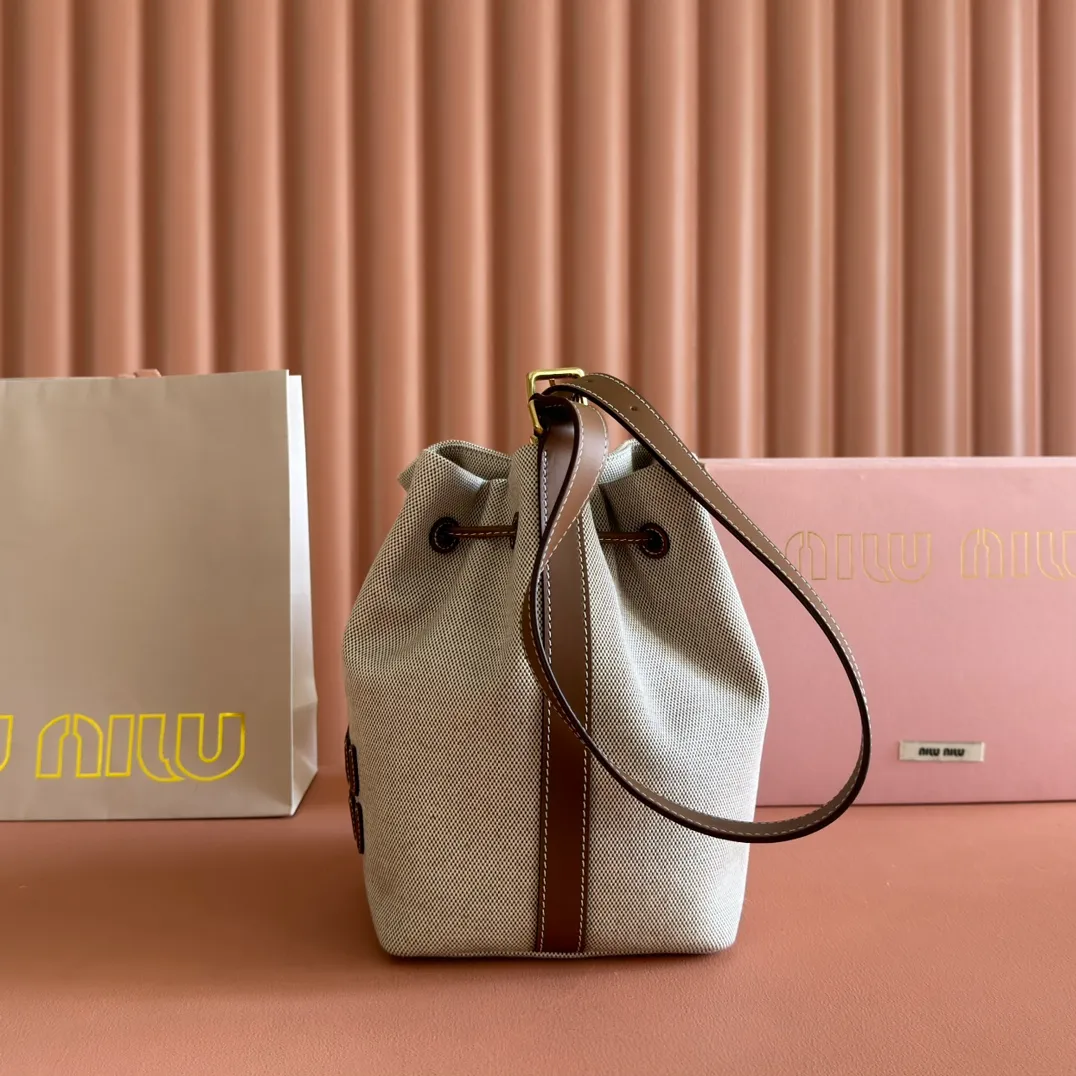 p1300💋💋💋【Full set of packaging at the counter】5BE089 Canvas Bucket Bag This canvas and leather bucket bag from Miu family is intertwined with contrasting materials and colors, highlighting its unique design features. The letter logo adds a unique personality to the design of this bag. Adjustable leather handles Gold-plated hardware Leather letter logo on front Leather drawstring closure Linen fabric lining Model: 5BE090 Dimensions: Height 16cm Width 22.5cm Length 14cm