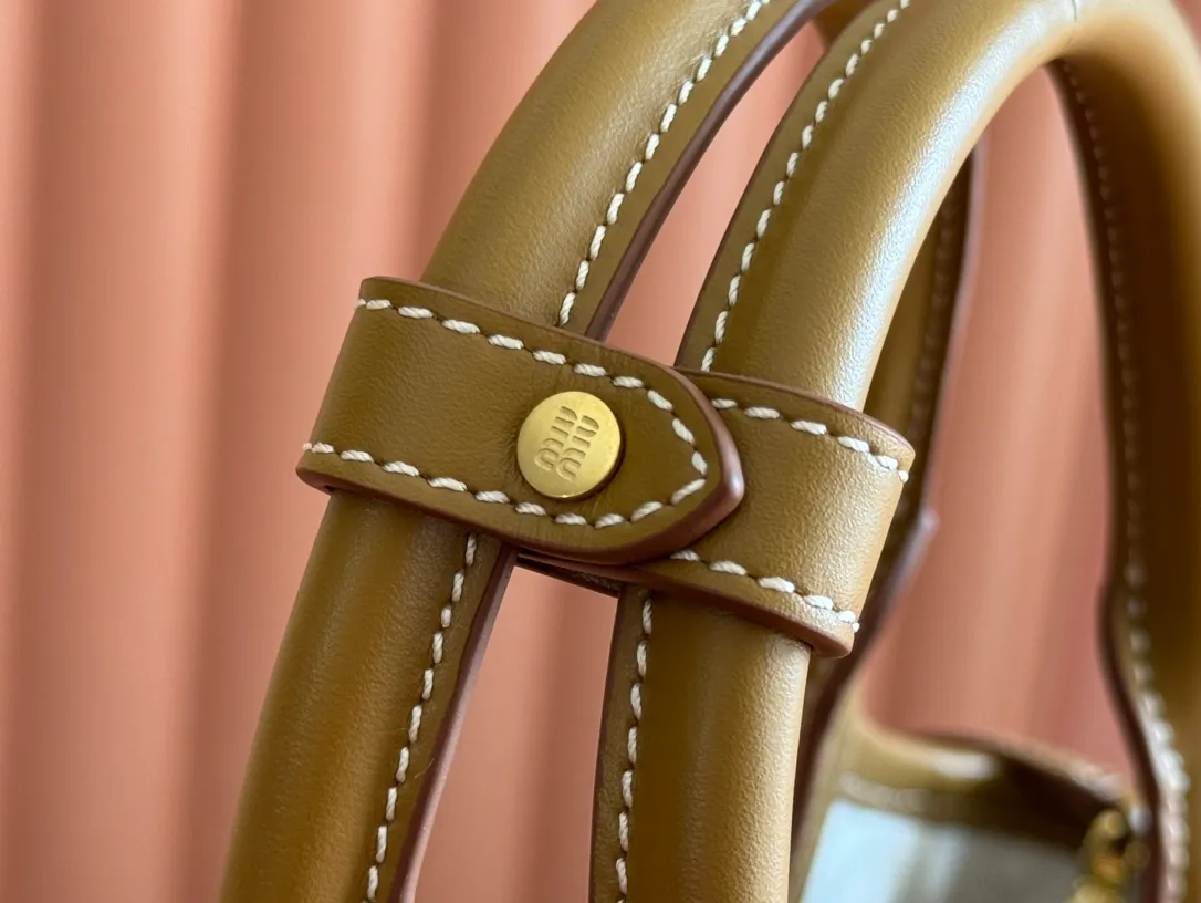 p1560. 💋💋💋【Full set of packaging at the counter】MIU’s new IVY handbag. Simple lines, urban style and high-quality leather are the key words of this new IVY handbag. It adopts an exquisite design and is embellished with letter logo, highlighting the classic style. Detachable and adjustable shoulder strap. Gold-tone hardware. Lettering logo on front, fabric lining, double zip pockets. Model: 5BA284 cognac color Size: 22*12*23.5cm