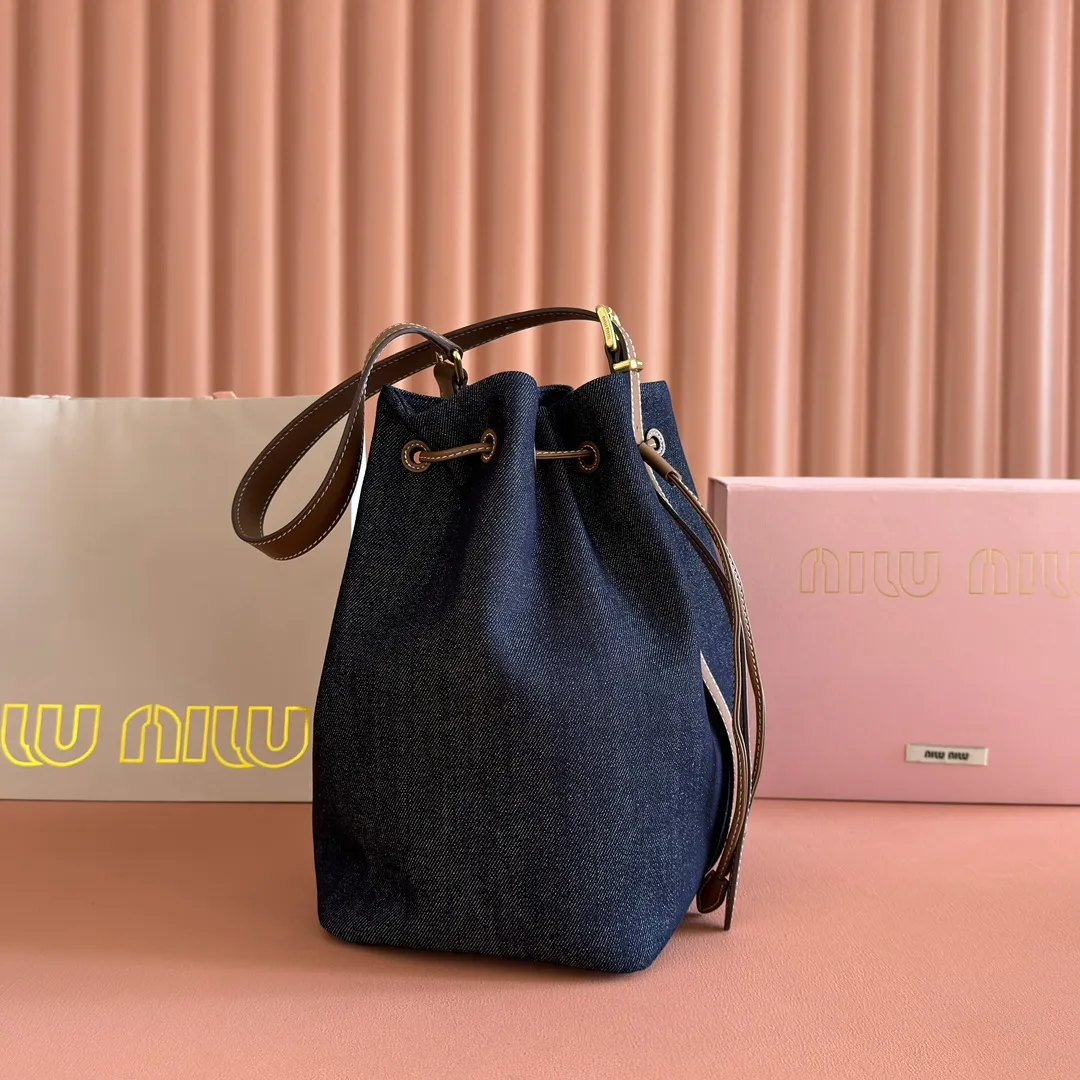 p1400💋💋💋【Full set of counter packaging】5BE089 Canvas Bucket Bag This canvas and leather bucket bag from Miu family is intertwined with contrasting materials and colors, highlighting its unique design features. The letter logo adds a unique personality to the design of this bag. Adjustable leather handles Gold-plated hardware Leather letter logo on front Leather drawstring closure Linen fabric lining Model: 5BE089 Dimensions: Height 29cm Width 17cm Length 23cm
