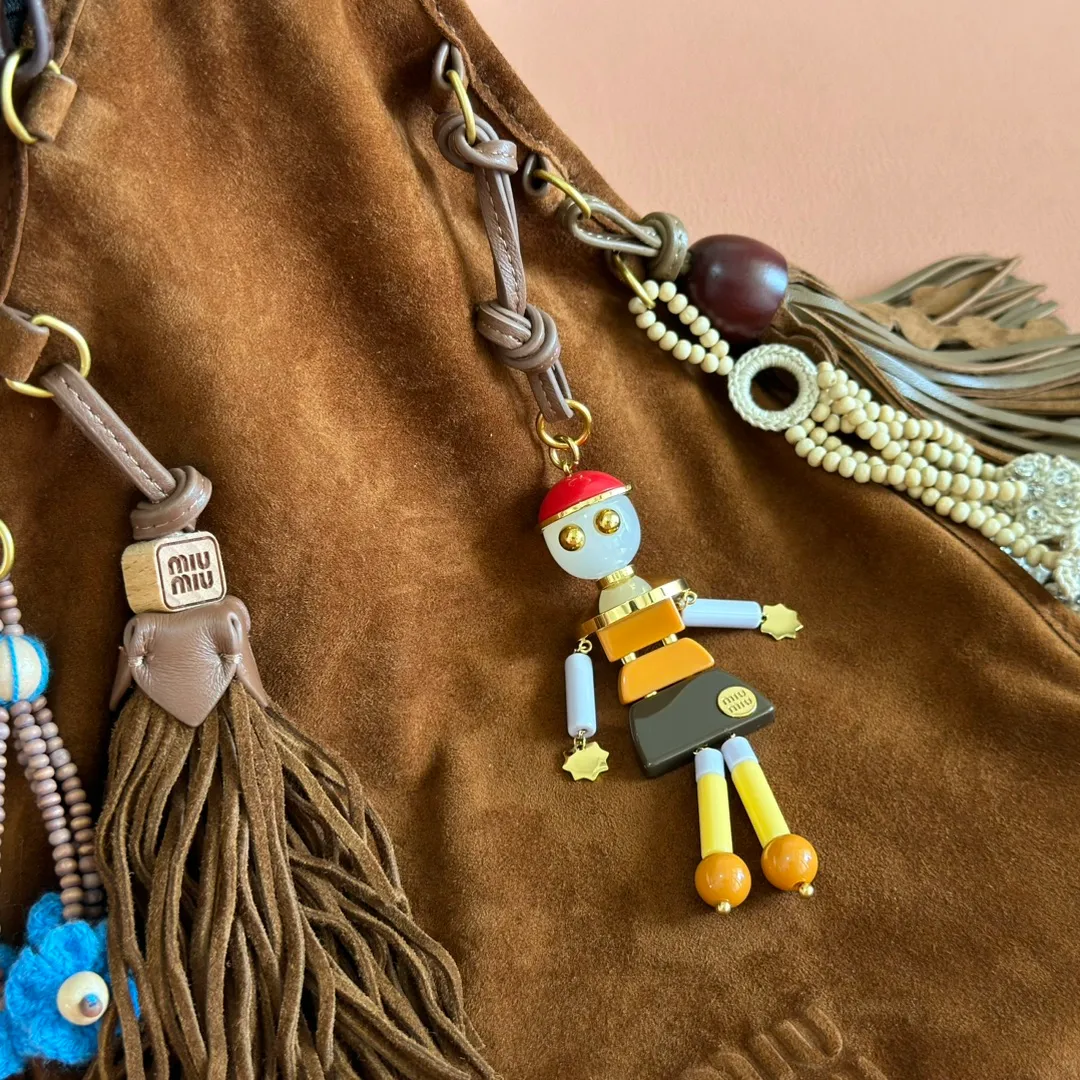 p1640💋💋💋【Full set of packaging at the counter, premium hardware and original leather】Suede sheepskin tassel handbag ~ miu design is interpreted from the perspective of lifestyle, presenting creative items, soft suede leather, enriching unique and accessories combinations through pendants, creating exclusive summer style in minutes. Super Q miu can always come up with new tricks, very porridge! The bag's vintage inspiration is enhanced by soft suede leather, enriched with unique accessories and embellishments via tassels and front loops. Size: W24×H37cm No.: 5BA295Miu 25ss limited show suede pendant bag
