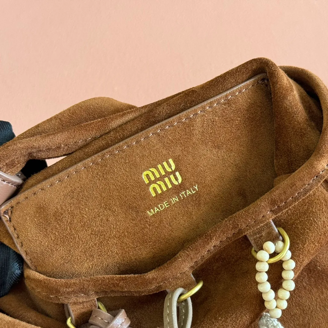 p1640💋💋💋【Full set of packaging at the counter, premium hardware and original leather】Suede sheepskin tassel handbag ~ miu design is interpreted from the perspective of lifestyle, presenting creative items, soft suede leather, enriching unique and accessories combinations through pendants, creating exclusive summer style in minutes. Super Q miu can always come up with new tricks, very porridge! The bag's vintage inspiration is enhanced by soft suede leather, enriched with unique accessories and embellishments via tassels and front loops. Size: W24×H37cm No.: 5BA295Miu 25ss limited show suede pendant bag