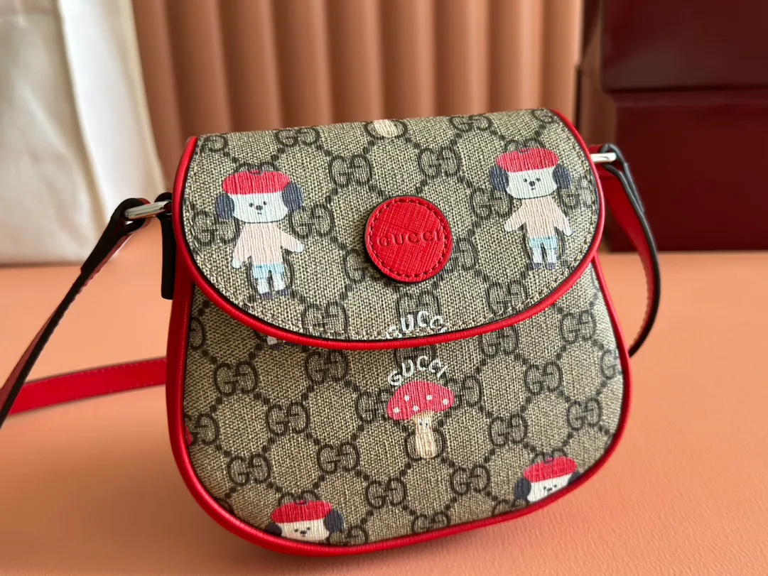 p880💋💋💋【Full set of counter packaging】Children's printed GG shoulder bag 814014 FAD5G Painter Naon Jeong draws inspiration from daily life and local culture to create interesting and nostalgic designs. She combines kitten prints and other fun patterns with the brand name to add color to the early spring 2025 children's collection. This children's shoulder bag is crafted from GG Supreme canvas with an all-over "what?" cat print. ·Beige and dark brown GG Supreme canvas ·Red Supreme canvas trim ·Naon Jeong illustration ·All-over "what?" kitten print ·Gucci embossed label ·Magnetic snap fastening ·16cm (width) x 15cm (height) x 2.5cm (depth) ·