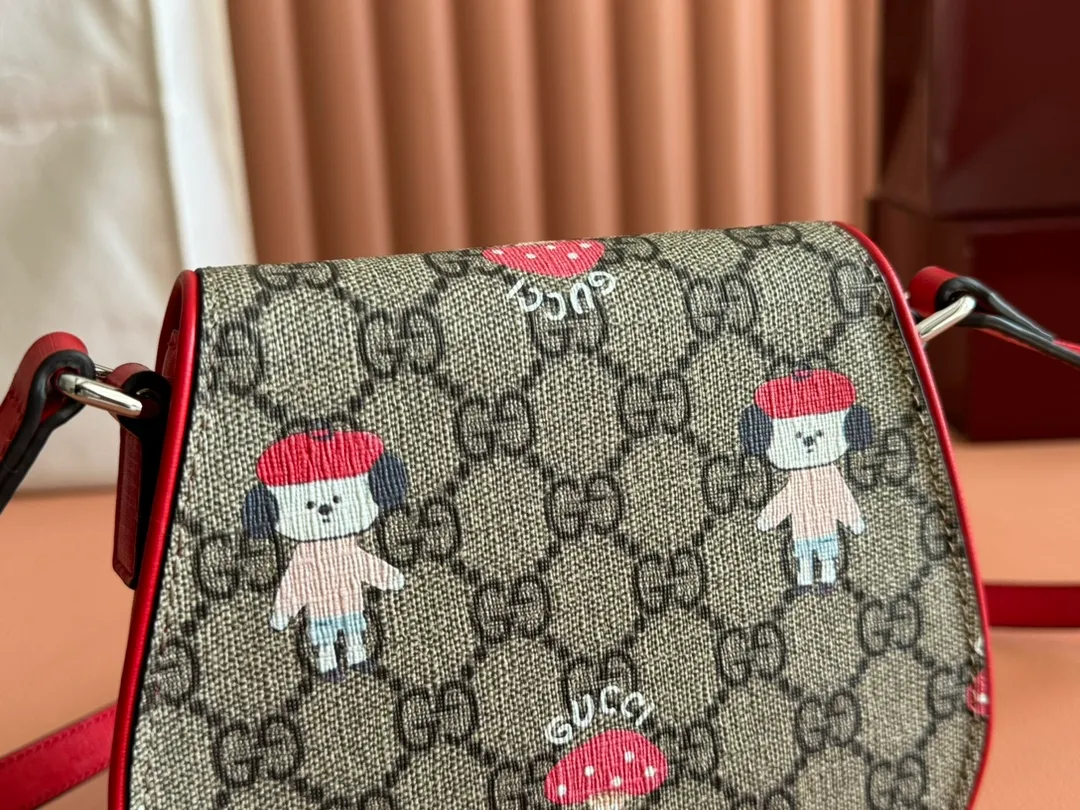 p880💋💋💋【Full set of counter packaging】Children's printed GG shoulder bag 814014 FAD5G Painter Naon Jeong draws inspiration from daily life and local culture to create interesting and nostalgic designs. She combines kitten prints and other fun patterns with the brand name to add color to the early spring 2025 children's collection. This children's shoulder bag is crafted from GG Supreme canvas with an all-over "what?" cat print. ·Beige and dark brown GG Supreme canvas ·Red Supreme canvas trim ·Naon Jeong illustration ·All-over "what?" kitten print ·Gucci embossed label ·Magnetic snap fastening ·16cm (width) x 15cm (height) x 2.5cm (depth) ·