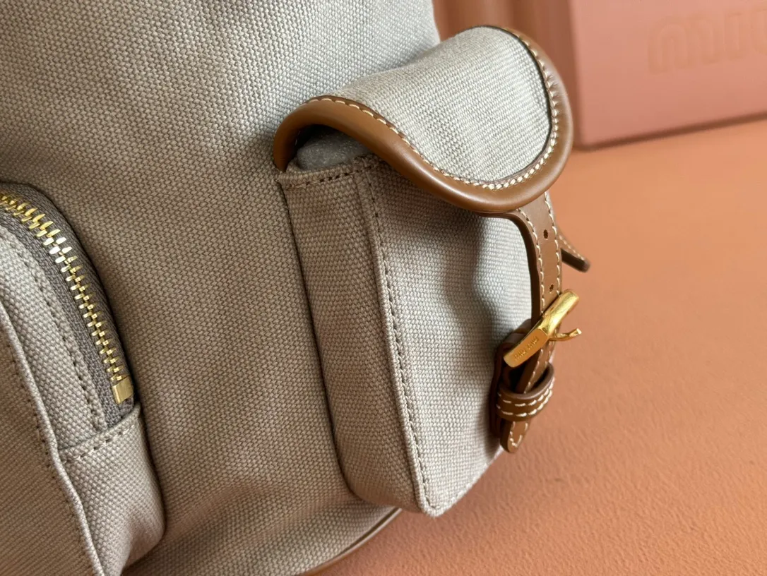 p1660. 💋💋💋【Configured with full package at counter】MIU Home new product college style backpack, the perfect combination of canvas and imported calfskin, thick wear-resistant linen blend lining, adopts a casual design style, fashionable, simple and advanced, combined with exquisite handcrafts, adding multiple pockets for storage, the shoulder strap and hand bag can be freely converted, which is a great convenience Improved practicality, it is simply a tool for dressing. It can be worn with jeans, shirts or various casual sportswear. It is a very good item to wear, especially the capacity is large enough and it is light and easy to use. I highly recommend it. Model: 5bz042, size 29.5x25x12.5cm