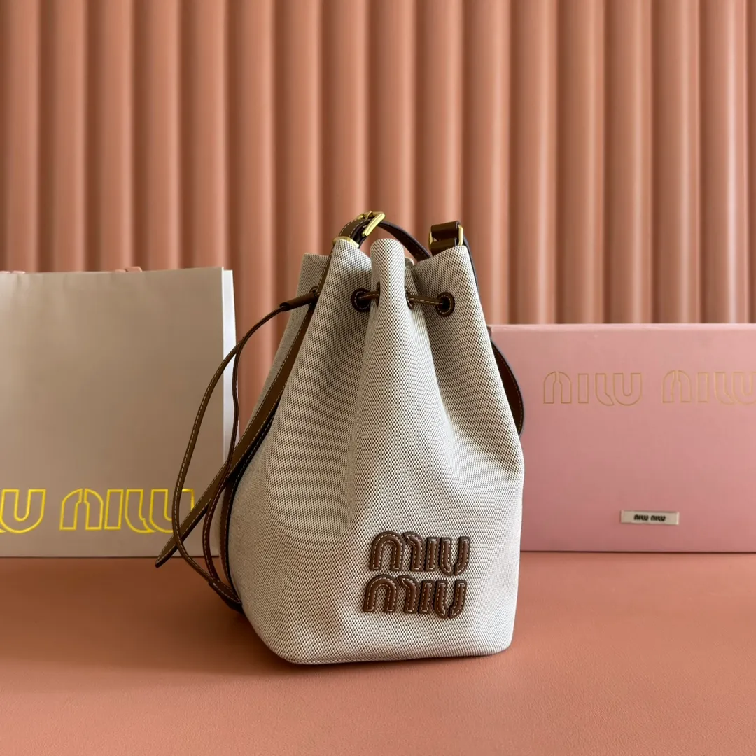 p1400💋💋💋【Full set of counter packaging】5BE089 Canvas Bucket Bag This canvas and leather bucket bag from Miu family is intertwined with contrasting materials and colors, highlighting its unique design features. The letter logo adds a unique personality to the design of this bag. Adjustable leather handles Gold-plated hardware Leather letter logo on front Leather drawstring closure Linen fabric lining Model: 5BE089 Dimensions: Height 29cm Width 17cm Length 23cm