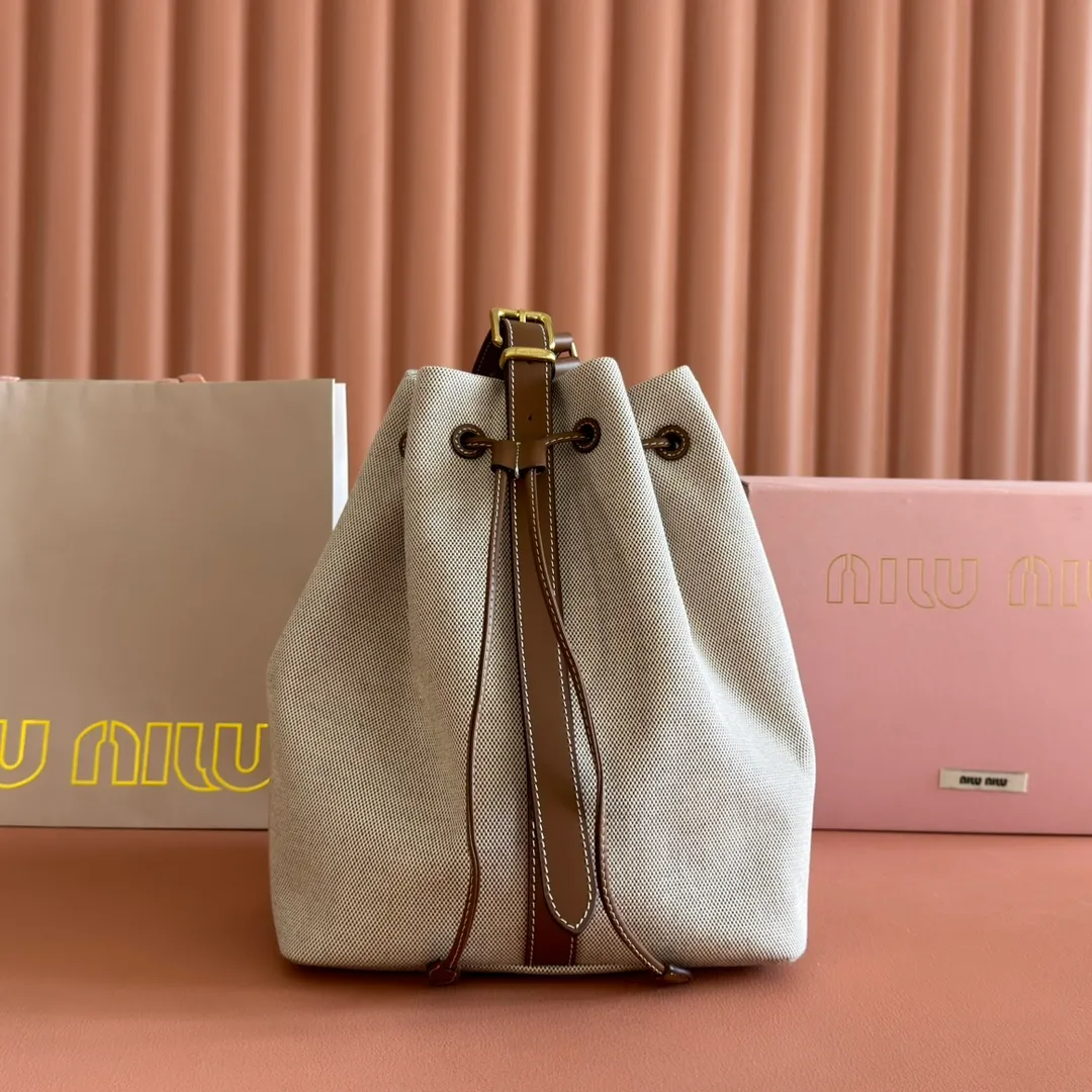 p1400💋💋💋【Full set of counter packaging】5BE089 Canvas Bucket Bag This canvas and leather bucket bag from Miu family is intertwined with contrasting materials and colors, highlighting its unique design features. The letter logo adds a unique personality to the design of this bag. Adjustable leather handles Gold-plated hardware Leather letter logo on front Leather drawstring closure Linen fabric lining Model: 5BE089 Dimensions: Height 29cm Width 17cm Length 23cm
