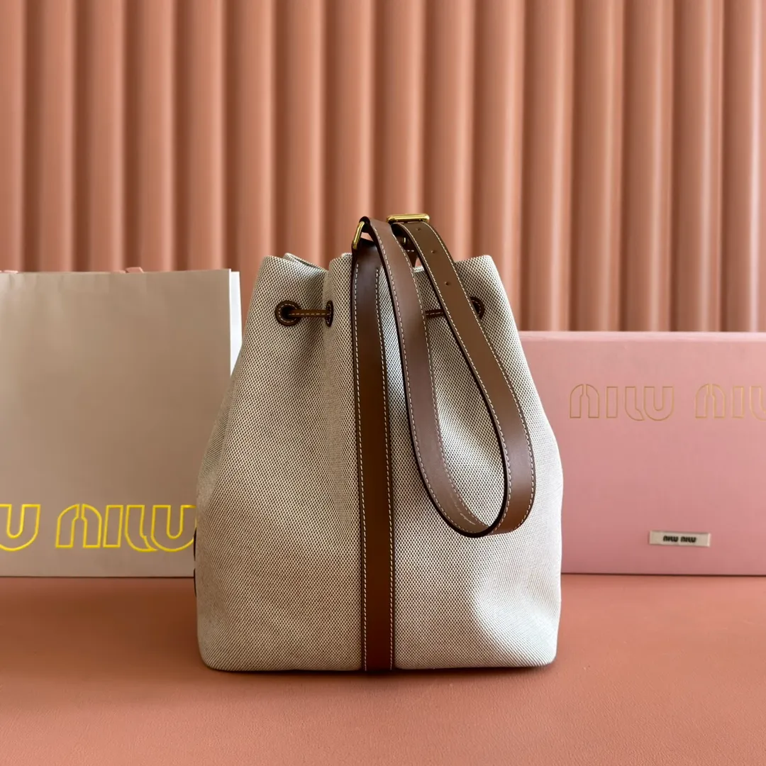 p1400💋💋💋【Full set of counter packaging】5BE089 Canvas Bucket Bag This canvas and leather bucket bag from Miu family is intertwined with contrasting materials and colors, highlighting its unique design features. The letter logo adds a unique personality to the design of this bag. Adjustable leather handles Gold-plated hardware Leather letter logo on front Leather drawstring closure Linen fabric lining Model: 5BE089 Dimensions: Height 29cm Width 17cm Length 23cm