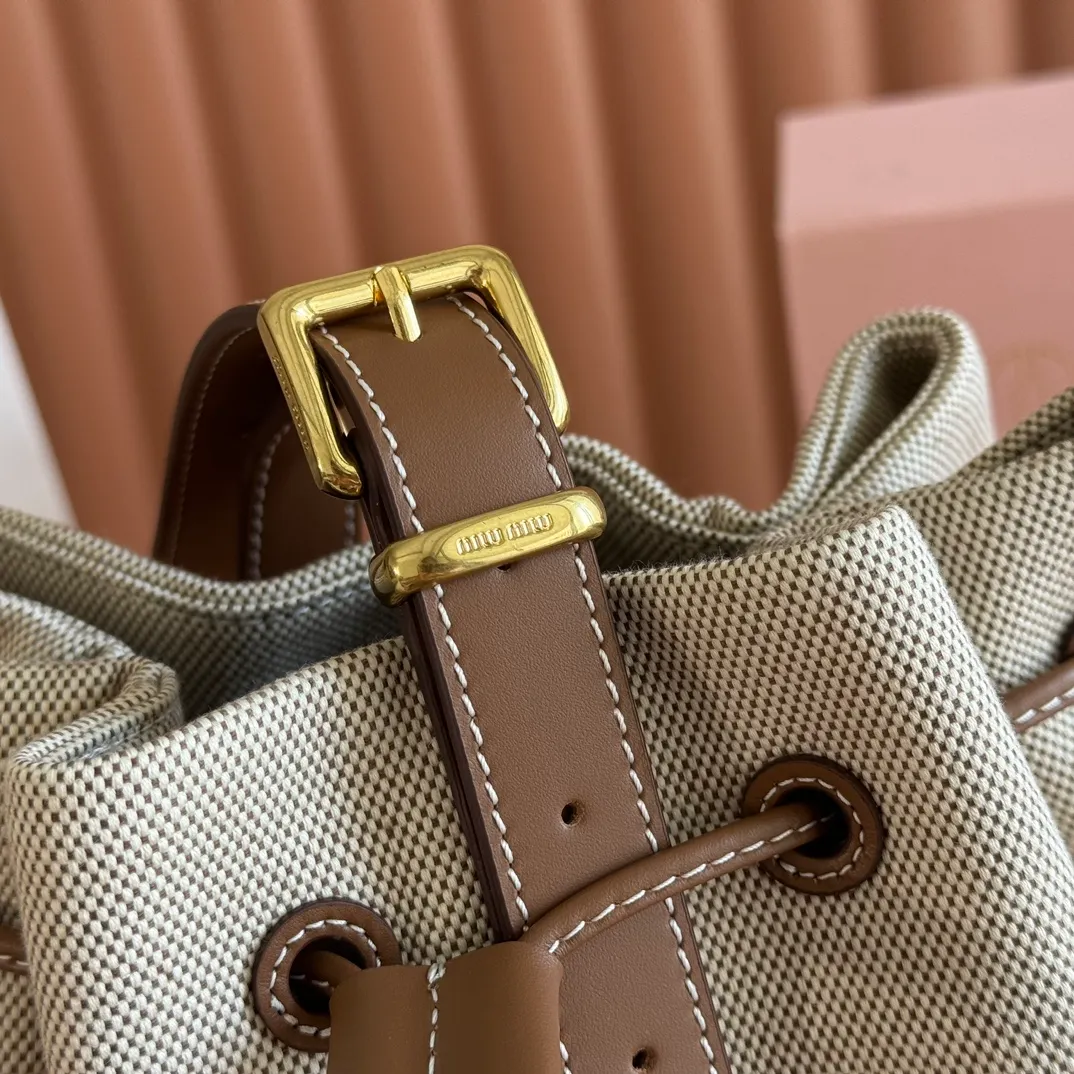 p1400💋💋💋【Full set of counter packaging】5BE089 Canvas Bucket Bag This canvas and leather bucket bag from Miu family is intertwined with contrasting materials and colors, highlighting its unique design features. The letter logo adds a unique personality to the design of this bag. Adjustable leather handles Gold-plated hardware Leather letter logo on front Leather drawstring closure Linen fabric lining Model: 5BE089 Dimensions: Height 29cm Width 17cm Length 23cm