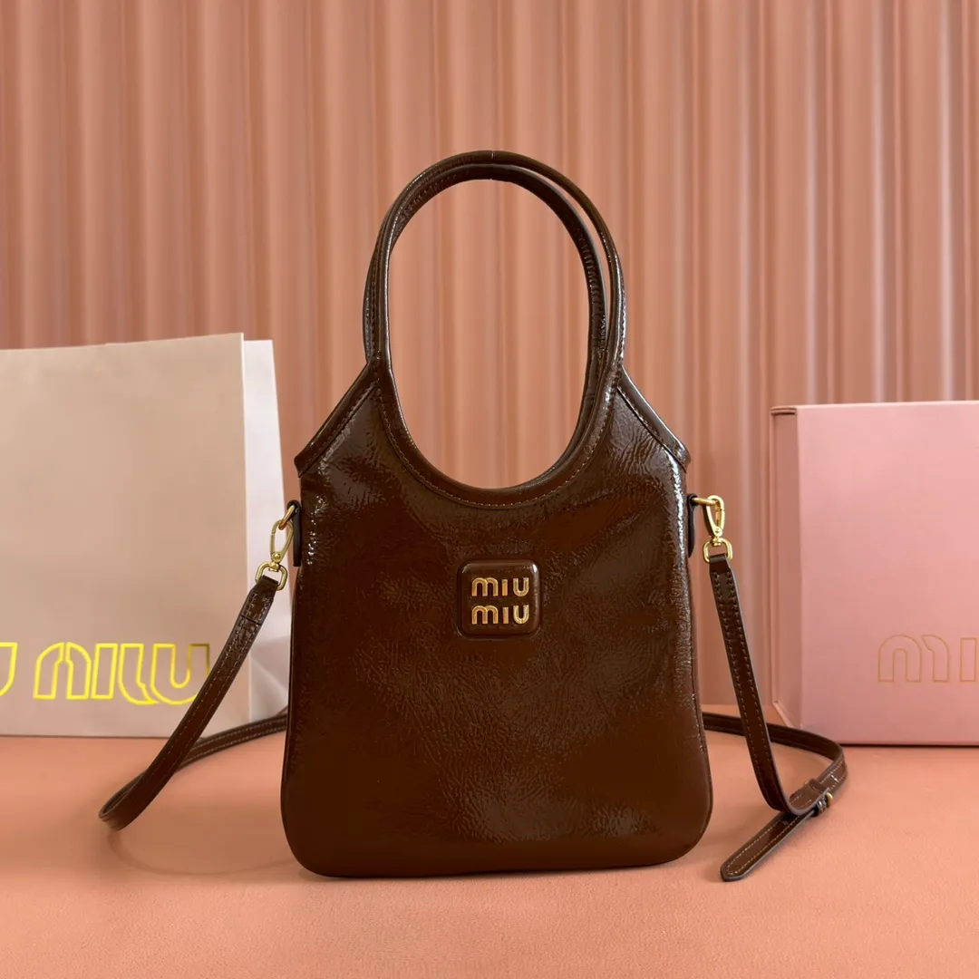 p1260. 💋💋💋【Full set of packaging at the counter】M's new mini tote bag, the new size is small and cute, highly adaptable, fashionable, chic and versatile, with exquisite details. The classic embossed letter logo adds a unique style and recognition, continuing the Miu retro style, casual and easy. It is equipped with a detachable and adjustable leather long shoulder strap, which can be carried on the shoulder or crossbody for better practicality. Satin lining, with patch pocket. Model: 5BA281. Size: 20cmx24cm. Color: waxed patent leather brown/original leather. Made in Italy