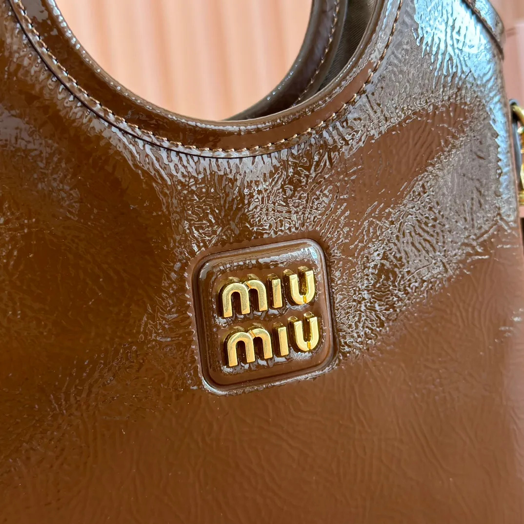 p1260. 💋💋💋【Full set of packaging at the counter】M's new mini tote bag, the new size is small and cute, highly adaptable, fashionable, chic and versatile, with exquisite details. The classic embossed letter logo adds a unique style and recognition, continuing the Miu retro style, casual and easy. It is equipped with a detachable and adjustable leather long shoulder strap, which can be carried on the shoulder or crossbody for better practicality. Satin lining, with patch pocket. Model: 5BA281. Size: 20cmx24cm. Color: waxed patent leather brown/original leather. Made in Italy