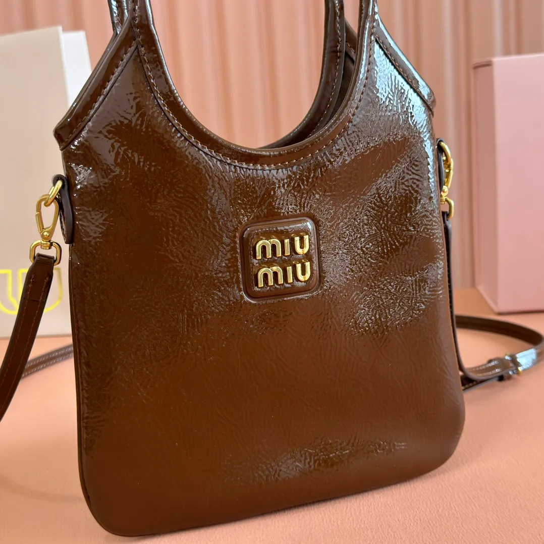 p1260. 💋💋💋【Full set of packaging at the counter】M's new mini tote bag, the new size is small and cute, highly adaptable, fashionable, chic and versatile, with exquisite details. The classic embossed letter logo adds a unique style and recognition, continuing the Miu retro style, casual and easy. It is equipped with a detachable and adjustable leather long shoulder strap, which can be carried on the shoulder or crossbody for better practicality. Satin lining, with patch pocket. Model: 5BA281. Size: 20cmx24cm. Color: waxed patent leather brown/original leather. Made in Italy