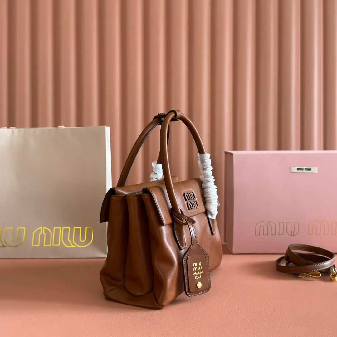 p1660💋💋💋【Configuring full counter package】Vintage cow leather Solitaire small handbag: 5BA301 Structured lines and exquisite details define this handbag, inspired by MiuMiu’s 2006 archives. An elegant style that combines classic and experimental is enhanced by the iconic logo on the front and a shiny finish. ·With handles ·Front and back pockets ·Golden hardware ·With zipper pocket and patch pockets ●Front lettering logo Width: 25cm, Height: 18cm, Length: 10cm?