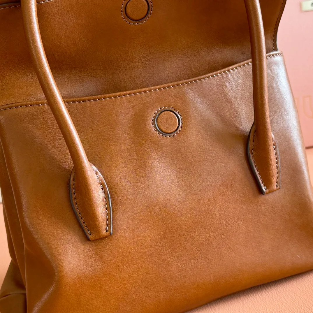 p1660💋💋💋【Configuring full counter package】Vintage cow leather Solitaire small handbag: 5BA301 Structured lines and exquisite details define this handbag, inspired by MiuMiu’s 2006 archives. An elegant style that combines classic and experimental is enhanced by the iconic logo on the front and a shiny finish. ·With handles ·Front and back pockets ·Golden hardware ·With zipper pocket and patch pockets ●Front lettering logo Width: 25cm, Height: 18cm, Length: 10cm?