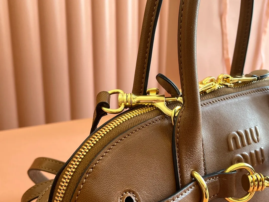 p2080💋💋💋【Original leather configuration counter packaging】Miu's new popular bowling bag, made of top-grade retro vegetable soft sheepskin, retro frosted old metal accessories, this Aventure Nappa leather handbag is inspired by A Miu collection item, its structure has been adjusted to become lighter and rejuvenate with a new personality, creating a classic bag with timeless charm. The multi-element design gives this handbag a unique beauty and classic atmosphere. It has a detachable and adjustable leather shoulder strap. The canvas lining is equipped with zipper pockets and patch pockets. Dimensions: 33 X16.5 X 10 cm. Model 5bb168