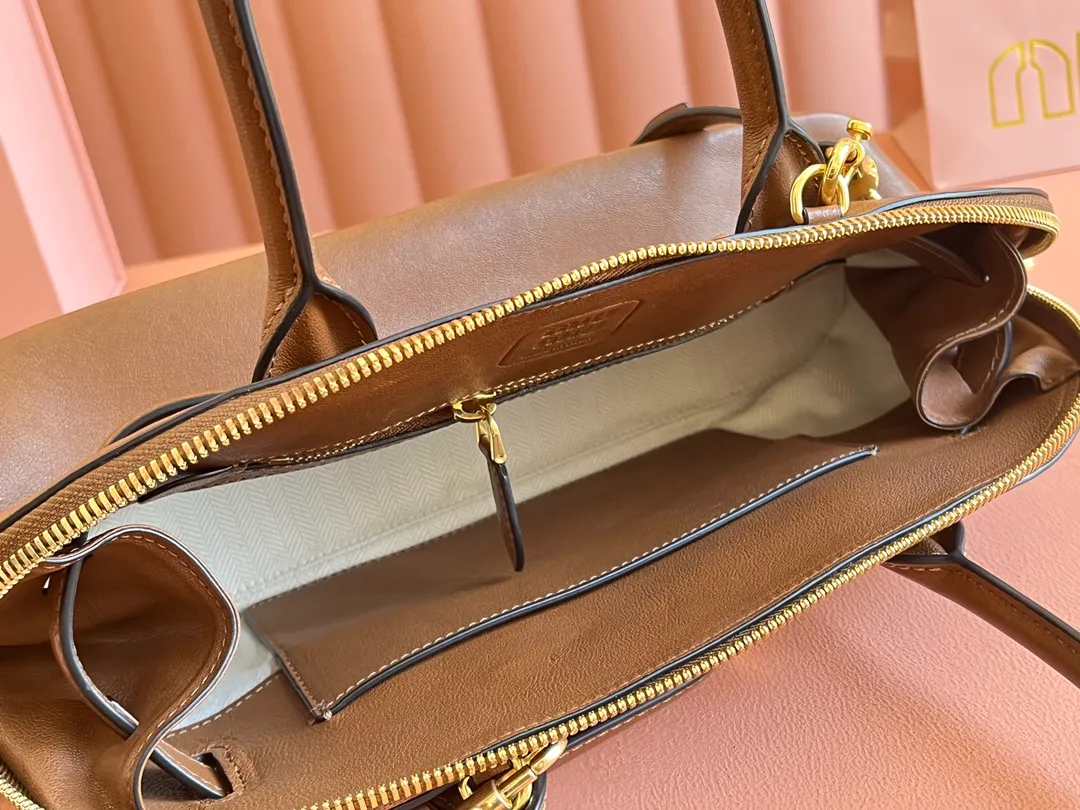 p2080💋💋💋【Original leather configuration counter packaging】Miu's new popular bowling bag, made of top-grade retro vegetable soft sheepskin, retro frosted old metal accessories, this Aventure Nappa leather handbag is inspired by A Miu collection item, its structure has been adjusted to become lighter and rejuvenate with a new personality, creating a classic bag with timeless charm. The multi-element design gives this handbag a unique beauty and classic atmosphere. It has a detachable and adjustable leather shoulder strap. The canvas lining is equipped with zipper pockets and patch pockets. Dimensions: 33 X16.5 X 10 cm. Model 5bb168