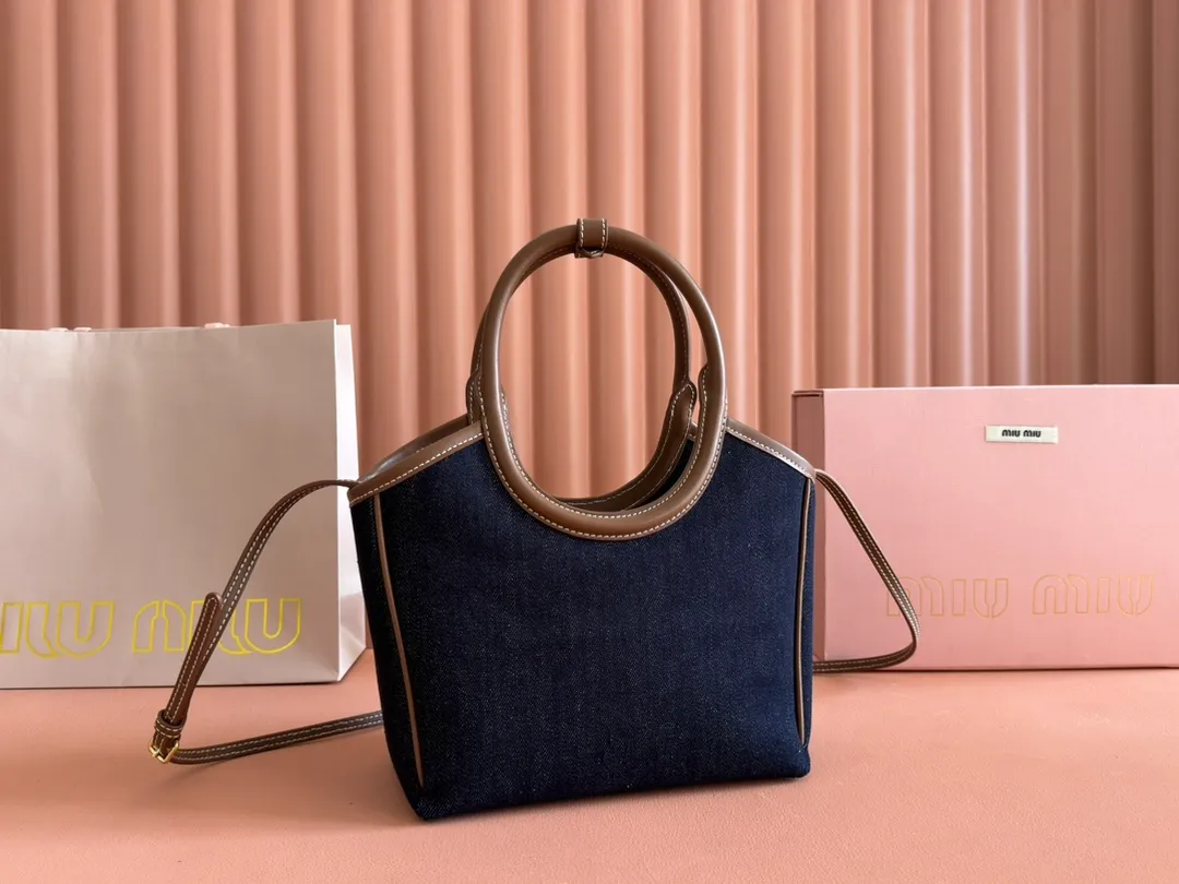 p1360. 💋💋💋【Full set of packaging at the counter】Miu's new product Isetan limited edition tote bag, promoted by the official website, absolutely popular this year🔥 style, top imported calfskin, the leather surface is delicate, smooth and soft, the superior leather texture is high-end, the bag body is soft but not collapsed, small size The design is more refined, and the temperament is casual and lazy. It will turn heads every day when you carry it on the street. It has hand-stitched leather logo, brand new linen lining, two zippered pockets, long adjustable leather shoulder strap, model 5BA288, size 22X 14X11Cm.