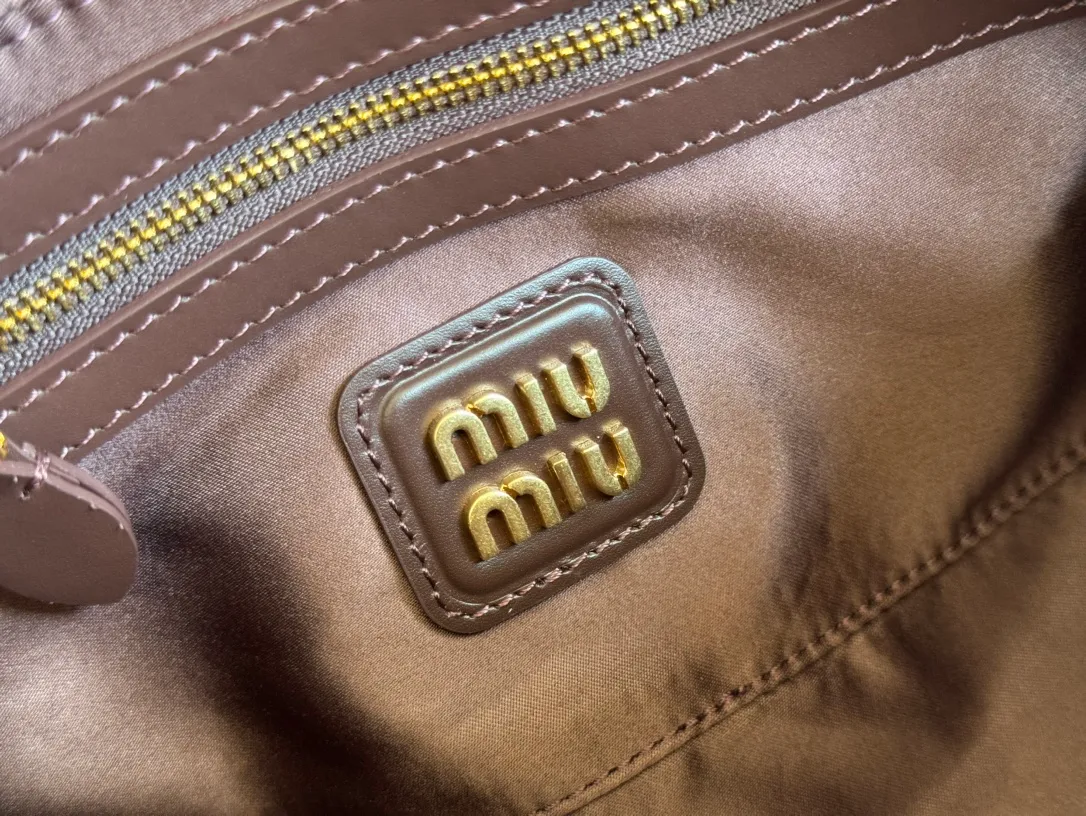 p1640💋💋💋【Full set of packaging at the counter】MIU MIU Miu Miu Caramel Bowling Upper Body Effect! Miu Miu Women's Arcadia Cowhide Handbag Crossbody Bag👝Lightly padded design makes the handbag look fuller, showing a cosmopolitan style. The letter logo, which echoes the finish of the metal hardware, straddles the line between function and decoration, giving this handbag a unique aesthetic and classic feel. Size: 22✖️10.5✖️7.5cm Style number: 5bb142 Heather color