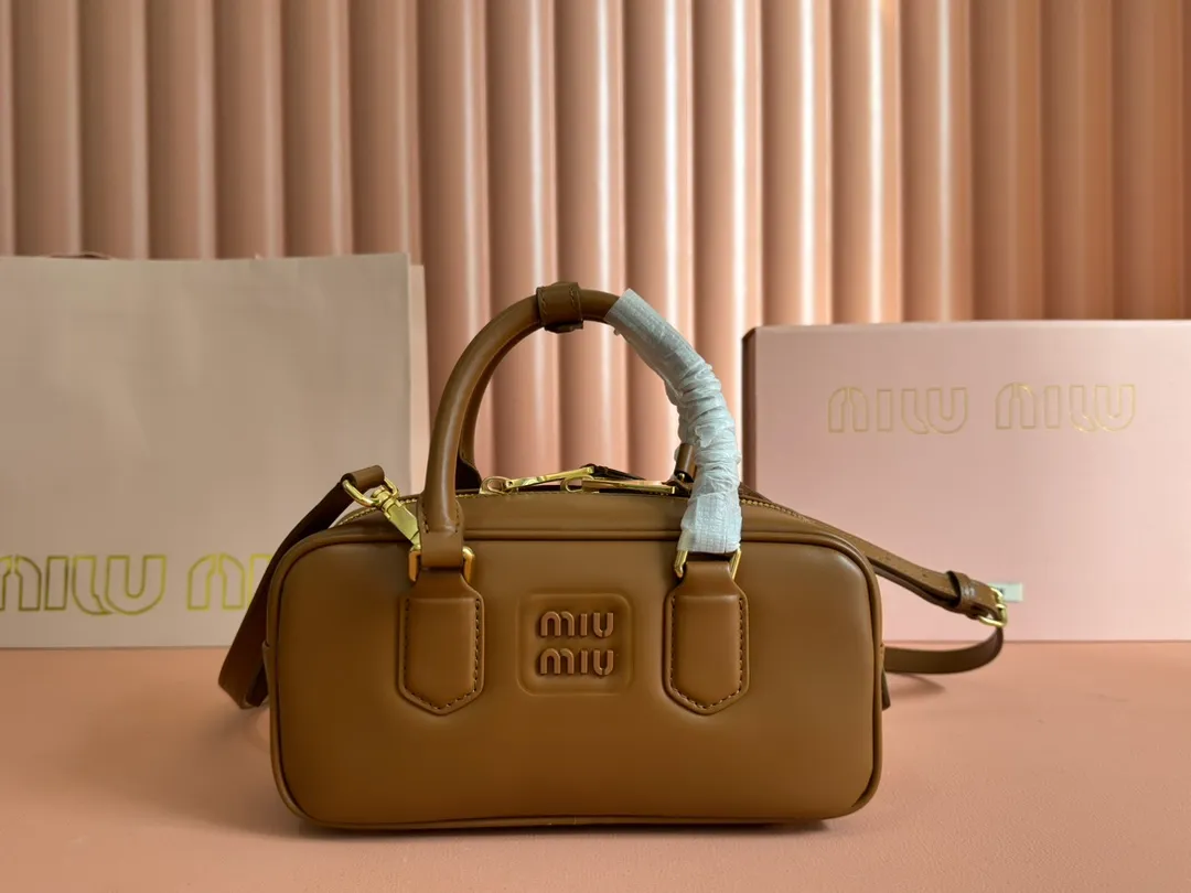 p1640💋💋💋【Full set of packaging at the counter】MIU MIU Miu Miu Caramel Bowling Upper Body Effect! Miu Miu Women's Arcadia Cowhide Handbag Crossbody Bag👝Lightly padded design makes the handbag look fuller, showing a cosmopolitan style. The letter logo, which echoes the finish of the metal hardware, straddles the line between function and decoration, giving this handbag a unique aesthetic and classic feel. Size: 22✖️10.5✖️7.5cm Style number: 5bb142 cognac color
