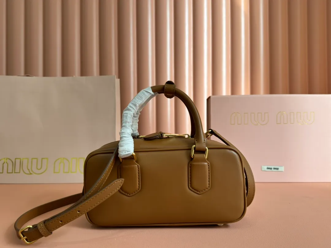 p1640💋💋💋【Full set of packaging at the counter】MIU MIU Miu Miu Caramel Bowling Upper Body Effect! Miu Miu Women's Arcadia Cowhide Handbag Crossbody Bag👝Lightly padded design makes the handbag look fuller, showing a cosmopolitan style. The letter logo, which echoes the finish of the metal hardware, straddles the line between function and decoration, giving this handbag a unique aesthetic and classic feel. Size: 22✖️10.5✖️7.5cm Style number: 5bb142 cognac color