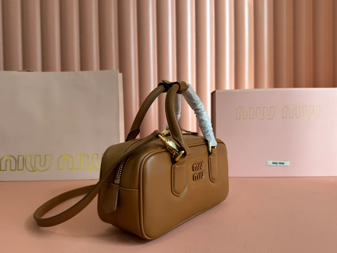 p1640💋💋💋【Full set of packaging at the counter】MIU MIU Miu Miu Caramel Bowling Upper Body Effect! Miu Miu Women's Arcadia Cowhide Handbag Crossbody Bag👝Lightly padded design makes the handbag look fuller, showing a cosmopolitan style. The letter logo, which echoes the finish of the metal hardware, straddles the line between function and decoration, giving this handbag a unique aesthetic and classic feel. Size: 22✖️10.5✖️7.5cm Style number: 5bb142 cognac color