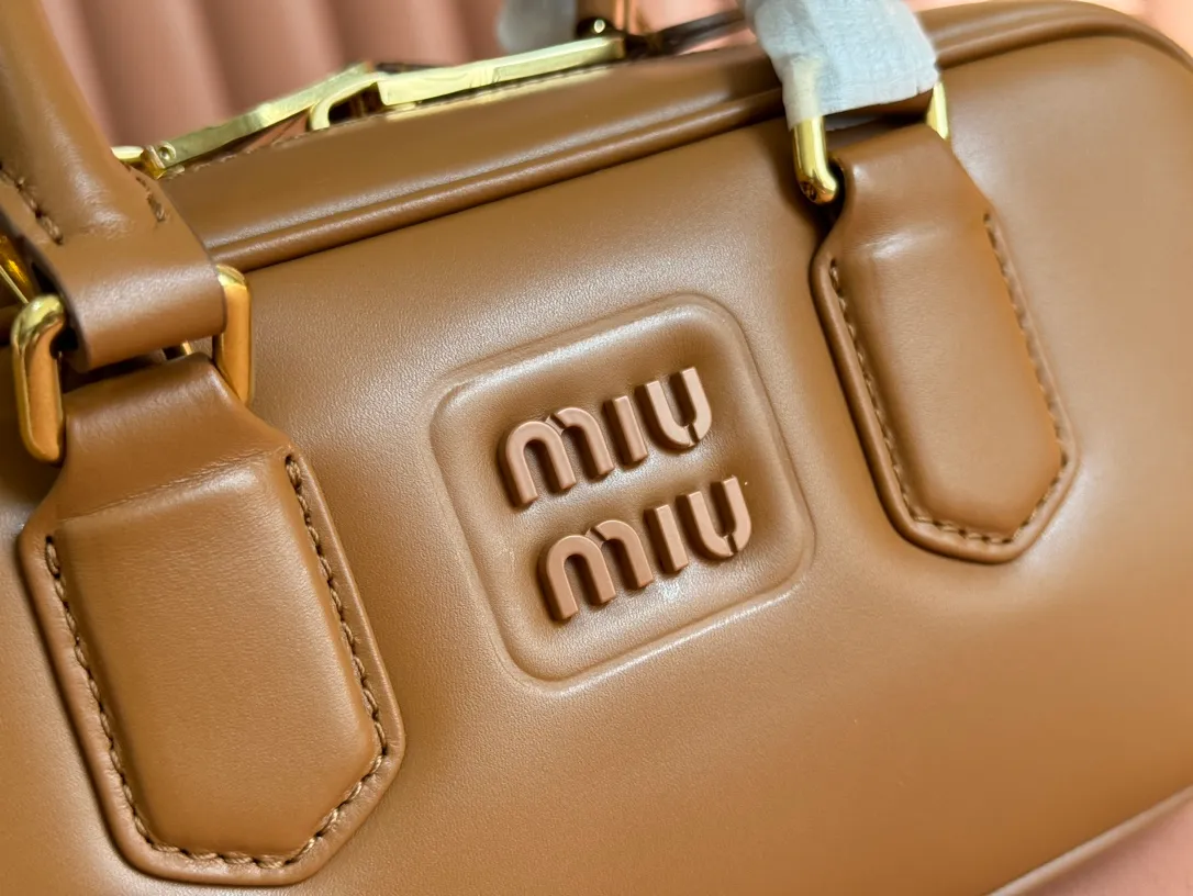 p1640💋💋💋【Full set of packaging at the counter】MIU MIU Miu Miu Caramel Bowling Upper Body Effect! Miu Miu Women's Arcadia Cowhide Handbag Crossbody Bag👝Lightly padded design makes the handbag look fuller, showing a cosmopolitan style. The letter logo, which echoes the finish of the metal hardware, straddles the line between function and decoration, giving this handbag a unique aesthetic and classic feel. Size: 22✖️10.5✖️7.5cm Style number: 5bb142 cognac color