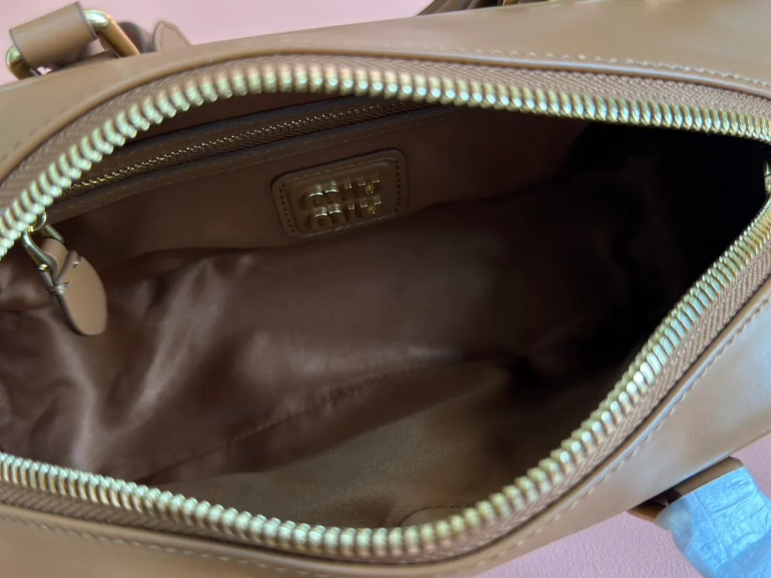 p1640💋💋💋【Full set of packaging at the counter】MIU MIU Miu Miu Caramel Bowling Upper Body Effect! Miu Miu Women's Arcadia Cowhide Handbag Crossbody Bag👝Lightly padded design makes the handbag look fuller, showing a cosmopolitan style. The letter logo, which echoes the finish of the metal hardware, straddles the line between function and decoration, giving this handbag a unique aesthetic and classic feel. Size: 22✖️10.5✖️7.5cm Style number: 5bb142 cognac color