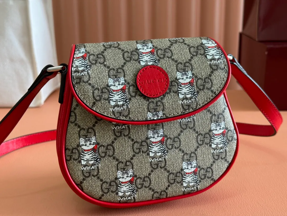 p880💋💋💋【Full set of counter packaging】Children's printed GG shoulder bag 814014 FAD5G Painter Naon Jeong draws inspiration from daily life and local culture to create interesting and nostalgic designs. She combines kitten prints and other fun patterns with the brand name to add color to the early spring 2025 children's collection. This children's shoulder bag is crafted from GG Supreme canvas with an all-over "what?" cat print. ·Beige and dark brown GG Supreme canvas ·Red Supreme canvas trim ·Naon Jeong illustration ·All-over "what?" kitten print ·Gucci embossed label ·Magnetic snap fastening ·16cm (width) x 15cm (height) x 2.5cm (depth) ·