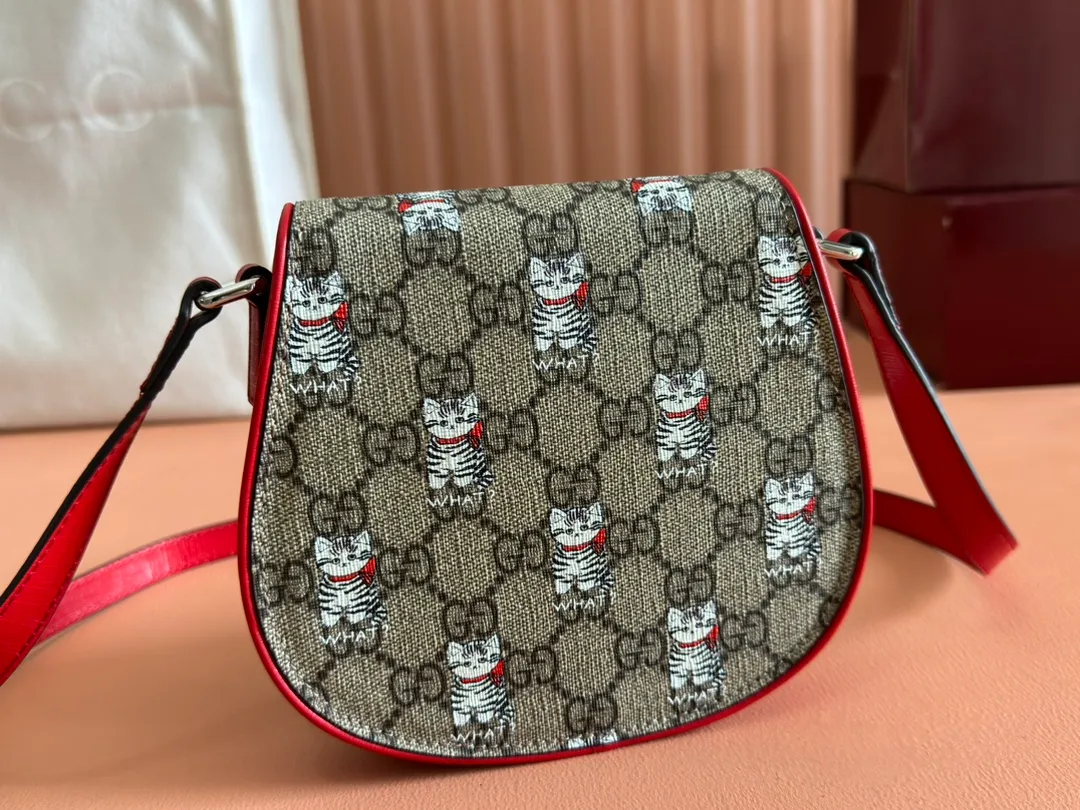 p880💋💋💋【Full set of counter packaging】Children's printed GG shoulder bag 814014 FAD5G Painter Naon Jeong draws inspiration from daily life and local culture to create interesting and nostalgic designs. She combines kitten prints and other fun patterns with the brand name to add color to the early spring 2025 children's collection. This children's shoulder bag is crafted from GG Supreme canvas with an all-over "what?" cat print. ·Beige and dark brown GG Supreme canvas ·Red Supreme canvas trim ·Naon Jeong illustration ·All-over "what?" kitten print ·Gucci embossed label ·Magnetic snap fastening ·16cm (width) x 15cm (height) x 2.5cm (depth) ·
