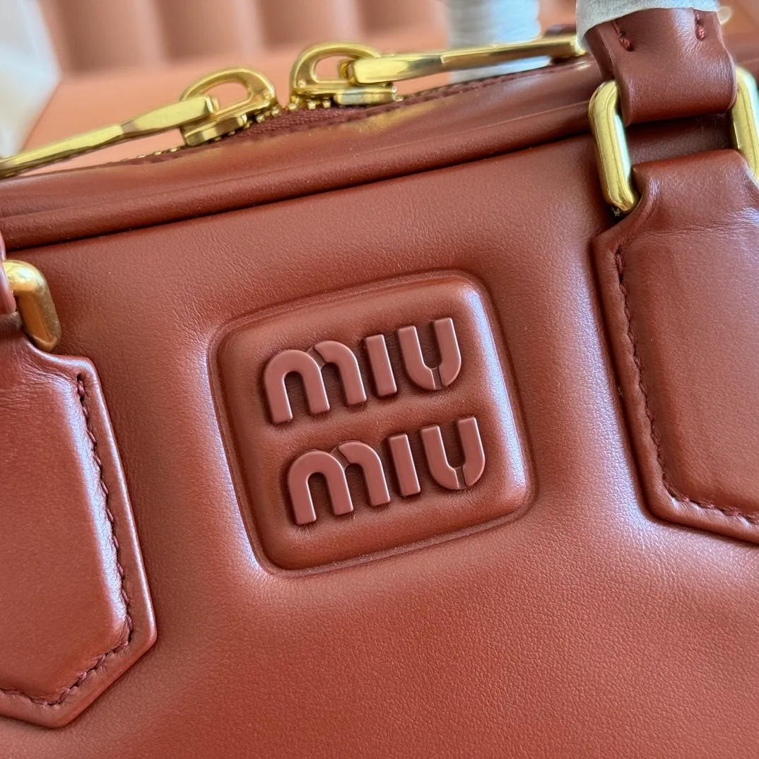 p1640💋💋💋【Full set of packaging at the counter】MIU MIU Miu Miu Caramel Bowling Upper Body Effect! Miu Miu Women's Arcadia Cowhide Handbag Crossbody Bag👝Lightly padded design makes the handbag look fuller, showing a cosmopolitan style. The letter logo, which echoes the finish of the metal hardware, straddles the line between function and decoration, giving this handbag a unique aesthetic and classic feel. Size: 22✖️10.5✖️7.5cm Style number: 5bb142