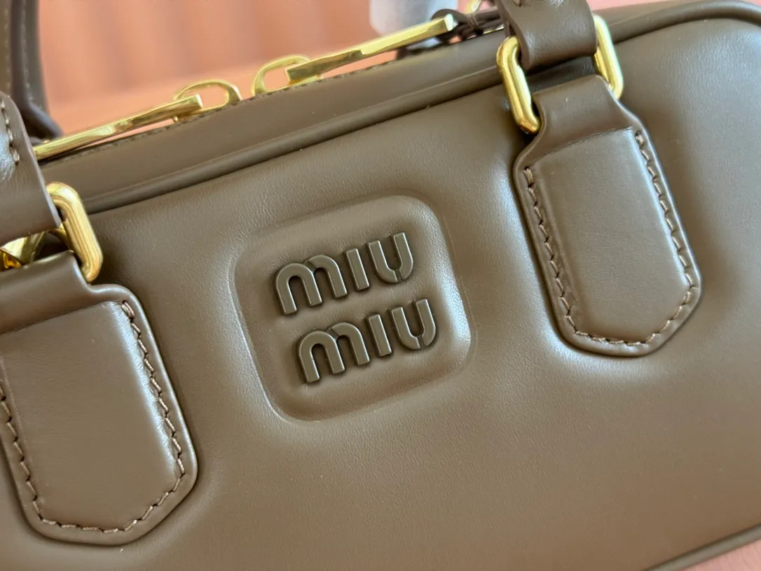 p1640💋💋💋【Full set of packaging at the counter】MIU MIU Miu Miu Caramel Bowling Upper Body Effect! Miu Miu Women's Arcadia Cowhide Handbag Crossbody Bag👝Lightly padded design makes the handbag look fuller, showing a cosmopolitan style. The letter logo, which echoes the finish of the metal hardware, straddles the line between function and decoration, giving this handbag a unique aesthetic and classic feel. Size: 22✖️10.5✖️7.5cm Style number: 5bb142 Tundra color