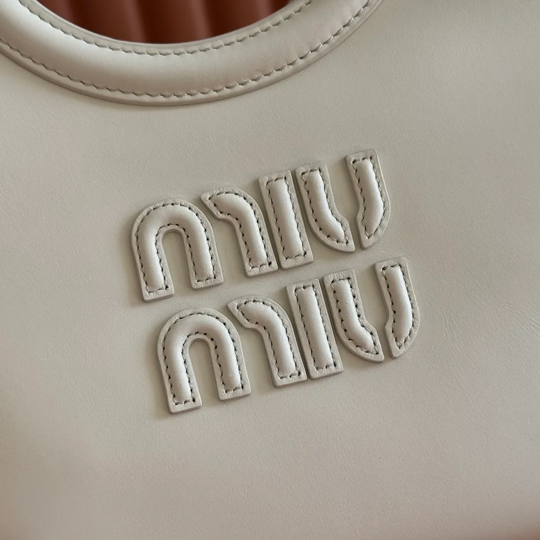 p1560. 💋💋💋【Full set of packaging at the counter】MIU’s new IVY handbag. Simple lines, urban style and high-quality leather are the key words of this new IVY handbag. It adopts an exquisite design and is embellished with letter logo, highlighting the classic style. Detachable and adjustable shoulder strap. Gold-tone hardware. Lettering logo on front, fabric lining, double zip pockets. Model: 5BA284 White Size: 22*12*23.5cm