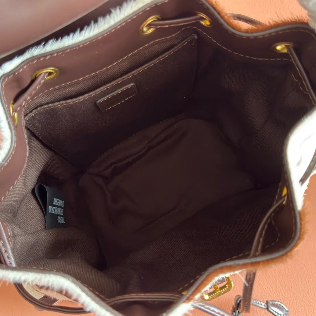 p1900💋💋💋【Original leather configuration counter complete package】𝐌𝐈𝐔𝐌𝐈𝐔 New cow pattern backpack Miu Miu's cow pattern backpack perfectly combines retro wildness and girly sweetness. The brown and white contrasting cow pattern fur material comes with an eye-catching buff, and is matched with the iconic logo embossing, showing the brand style in every detail; the drawstring flap design combines practicality with retro charm, and the combination of leather handles and shoulder straps, 🉑hand-held🉑shoulder-carrying, easily adapts to different wearing scenarios. Whether paired with casual denim or a sweet girl-style skirt, it can instantly inject a personal touch into the look and is the finishing touch to unlock niche fashion. Style number: 5B043 Small size: bottom length 23x height 25x width 13cm