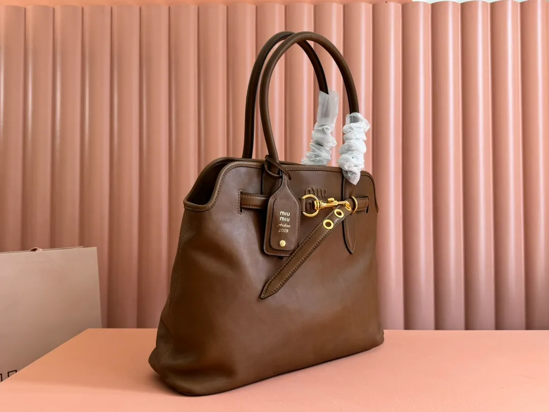 p2300💋💋💋Original leather Miu women's Nappa sheepskin handbag, inspired by the archive design, the structure has been adjusted to become lighter and rejuvenate with a new personality, creating a classic item with timeless charm. Decorated with an embossed monogram logo for an added signature touch 👝 Comes with handles for use as a tote or shoulder bag! Removable charm, antiqued gold-tone hardware, embossed lettering logo on front, lined interior, zip pocket and patch pocket! Size: 31✖️40✖️13cm Style number: 5BG291