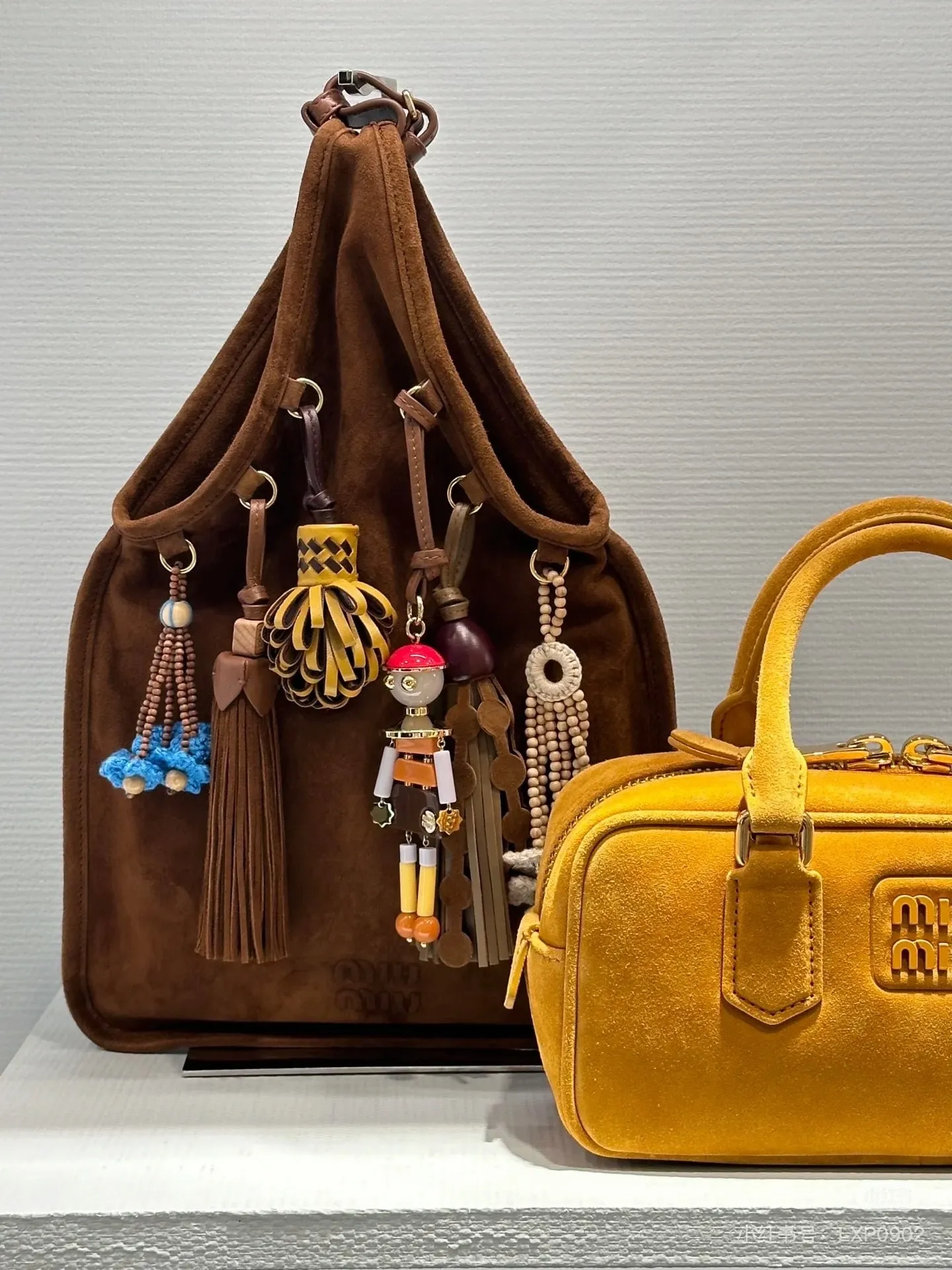 p1640💋💋💋【Full set of packaging at the counter, premium hardware and original leather】Suede sheepskin tassel handbag ~ miu design is interpreted from the perspective of lifestyle, presenting creative items, soft suede leather, enriching unique and accessories combinations through pendants, creating exclusive summer style in minutes. Super Q miu can always come up with new tricks, very porridge! The bag's vintage inspiration is enhanced by soft suede leather, enriched with unique accessories and embellishments via tassels and front loops. Size: W24×H37cm No.: 5BA295Miu 25ss limited show suede pendant bag