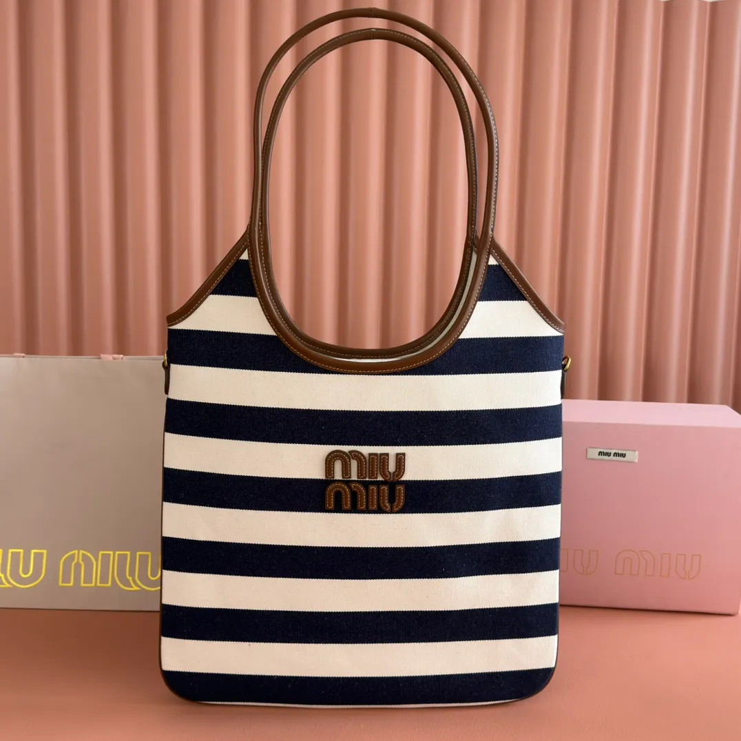 p1300. 💋💋💋【Full set of packages at the counter】𝗠𝗜𝗨𝗠𝗜𝗨 𝗙𝗪𝟮𝟱 𝗡𝗲𝘄 𝗮𝗿𝗿𝗶𝘃𝗮𝗹!      When striped canvas meets hobo's lazy gene, it grabs the first wave in autumn and winter. The relaxed feeling of commuting is directly capped. Classic blue and white nautical striped canvas × Italian calfskin piping. Flexible bag body hangs naturally. Tote capacity + Hobo's lazy feeling two-in-one. It looked like it was 𝗷𝗮𝗰𝗸𝗲𝘁 canvas, but when I touched the edge of the leather, I realized it was 𝗹𝘂𝘅𝘂𝗿𝘆!   The Ju Neng suit still hasn’t collapsed! 𝗵𝗼𝗯𝗼Bag shape looks slim 𝟭𝟬𝟬% 5BG231 stripes Size: 35×40cm