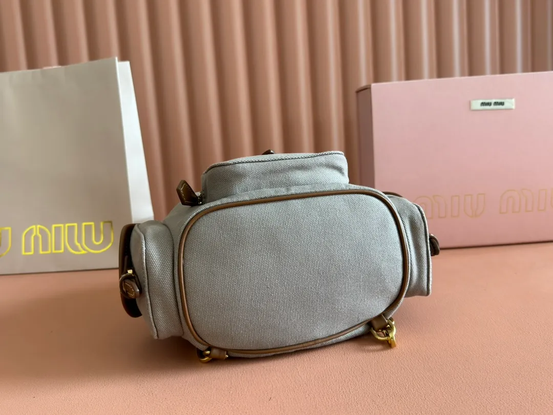 p1560. 💋💋💋【Configured with full package at counter】MIU Home new product college style backpack, the perfect combination of canvas and imported calfskin, thick wear-resistant linen blend lining, adopts a casual design style, fashionable, simple and advanced, combined with exquisite handcrafts, adds multiple pocket storage, shoulder straps and hand bags can be freely converted, greatly It improves the practicality. It is simply a tool for hanging. It can be worn with jeans, shirts or various casual sportswear. It is a very good item to wear, especially the capacity is large enough and it is light and easy to use. I sincerely recommend it. Model: 5bz043, size 22X18X11.5cm