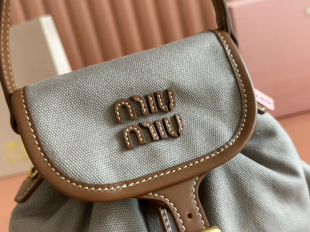 p1560. 💋💋💋【Configured with full package at counter】MIU Home new product college style backpack, the perfect combination of canvas and imported calfskin, thick wear-resistant linen blend lining, adopts a casual design style, fashionable, simple and advanced, combined with exquisite handcrafts, adds multiple pocket storage, shoulder straps and hand bags can be freely converted, greatly It improves the practicality. It is simply a tool for hanging. It can be worn with jeans, shirts or various casual sportswear. It is a very good item to wear, especially the capacity is large enough and it is light and easy to use. I sincerely recommend it. Model: 5bz043, size 22X18X11.5cm
