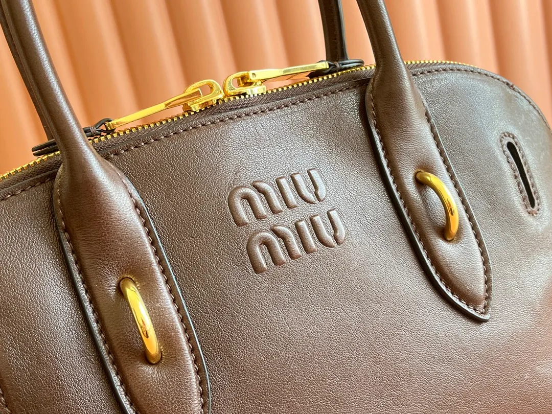 p2080💋💋💋【Original leather configuration counter packaging】Miu's new popular bowling bag, made of top-grade retro vegetable soft sheepskin, retro frosted old metal accessories, this Aventure Nappa leather handbag is inspired by A Miu collection item, its structure has been adjusted to become lighter and rejuvenate with a new personality, creating a classic bag with timeless charm. The multi-element design gives this handbag a unique beauty and classic atmosphere. It has a detachable and adjustable leather shoulder strap. The canvas lining is equipped with zipper pockets and patch pockets. Dimensions: 33 X16.5 X 10 cm. Model 5bb168