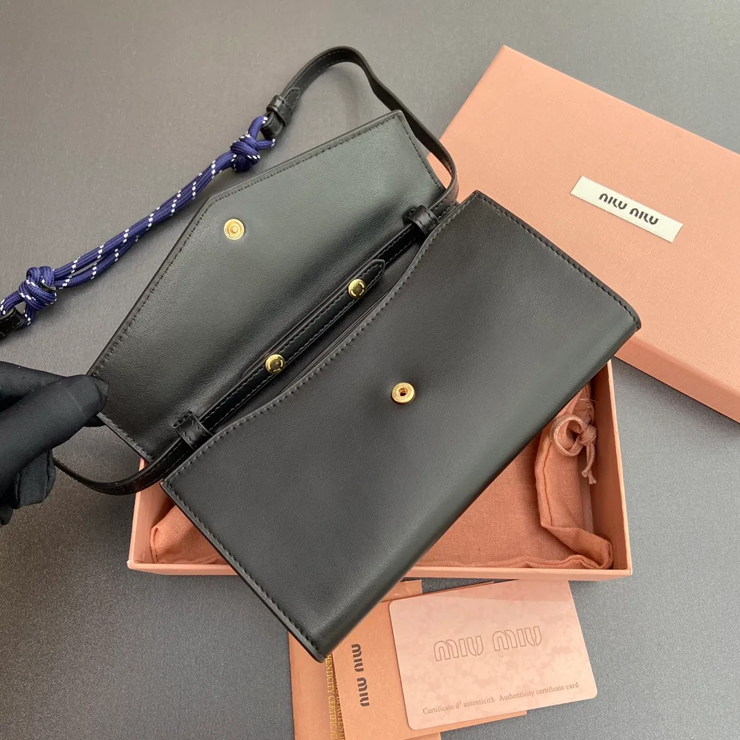 [Premium Hardware Original Leather] ¥880 ~ Black imported cow leather and rope shoulder strap cow leather wallet. The shoulder strap of this urban style wallet is embellished with ropes that are full of rugged, playful and sporty style, creating a contrasting effect of color, texture and style. - Snap button closure - Metal letter logo - Six card slots - One inner pocket - Lined - Detachable and adjustable shoulder strap Size: w19×h9.5×2cm No.: 5MT025_ 025 _MM034