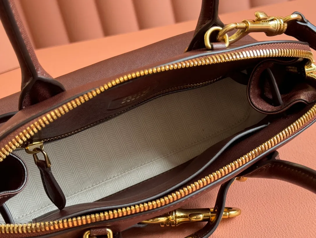 p1900💋💋💋【Original leather configuration counter packaging】Miu's new popular bowling bag, using top-grade retro vegetable soft sheepskin, retro frosted old metal accessories, this Aventure Nappa leather handbag is inspired by A Miu collection item, its structure has been adjusted to become lighter and rejuvenate with a new personality, creating a classic bag with timeless charm. The multi-element design gives this handbag a unique beauty and classic atmosphere. It has a detachable and adjustable leather shoulder strap. The canvas lining is equipped with zipper pockets and patch pockets. Dimensions: 28 X16.5 X 10 cm. Model 5bb169