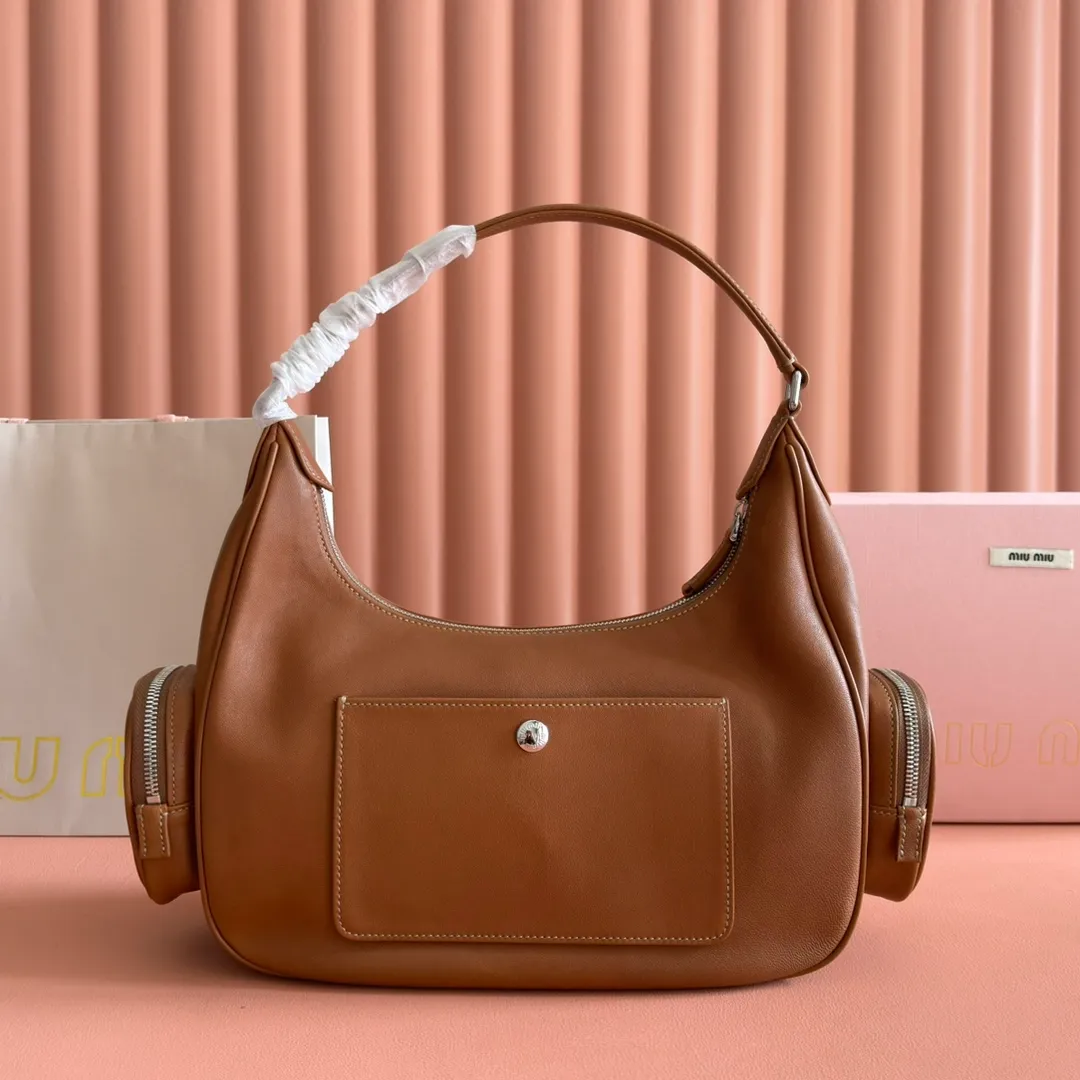 p2200💋💋💋【Full set of packaging at the counter】𝗠𝗶𝘂 𝗠𝗶𝘂 𝗣𝗼𝗰𝗸𝗲𝘁Motorcycle bag This MIU pocket bag is so big that even a rich family’s daughter is carrying it! Full leather inside and out, the leather is very soft and feels super good. The Tori zipper + three-dimensional pockets are retro and can be carried in one bag under the arm to unlock two ways of carrying it. Fashionable girls, please plant this motorcycle bag! Size: 38cm long (measured including the 2 side pockets, 33cm excluding it) Style number: 5BC189 caramel color Dimensions: length 38×width 14×height 20cm