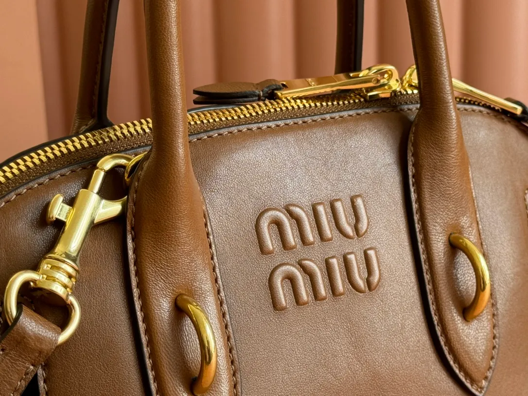 p1900💋💋💋【Original leather configuration counter packaging】Miu's new popular bowling bag, using top-grade retro vegetable soft sheepskin, retro frosted old metal accessories, this Aventure Nappa leather handbag is inspired by A Miu collection item, its structure has been adjusted to become lighter and rejuvenate with a new personality, creating a classic bag with timeless charm. The multi-element design gives this handbag a unique beauty and classic atmosphere. It has a detachable and adjustable leather shoulder strap. The canvas lining is equipped with zipper pockets and patch pockets. Dimensions: 28 X16.5 X 10 cm. Model 5bb169