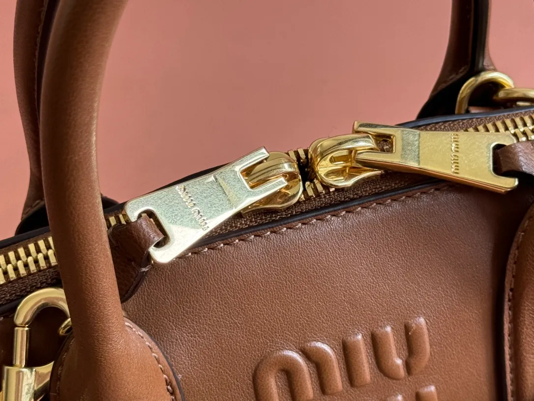 p1900💋💋💋【Original leather configuration counter packaging】Miu's new popular bowling bag, using top-grade retro vegetable soft sheepskin, retro frosted old metal accessories, this Aventure Nappa leather handbag is inspired by A Miu collection item, its structure has been adjusted to become lighter and rejuvenate with a new personality, creating a classic bag with timeless charm. The multi-element design gives this handbag a unique beauty and classic atmosphere. It has a detachable and adjustable leather shoulder strap. The canvas lining is equipped with zipper pockets and patch pockets. Dimensions: 28 X16.5 X 10 cm. Model 5bb169