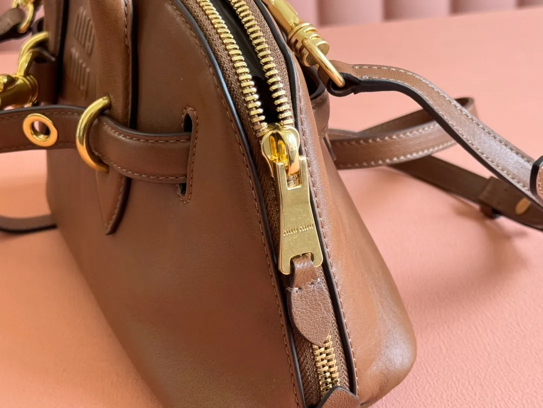 p1900💋💋💋【Original leather configuration counter packaging】Miu's new popular bowling bag, using top-grade retro vegetable soft sheepskin, retro frosted old metal accessories, this Aventure Nappa leather handbag is inspired by A Miu collection item, its structure has been adjusted to become lighter and rejuvenate with a new personality, creating a classic bag with timeless charm. The multi-element design gives this handbag a unique beauty and classic atmosphere. It has a detachable and adjustable leather shoulder strap. The canvas lining is equipped with zipper pockets and patch pockets. Dimensions: 28 X16.5 X 10 cm. Model 5bb169