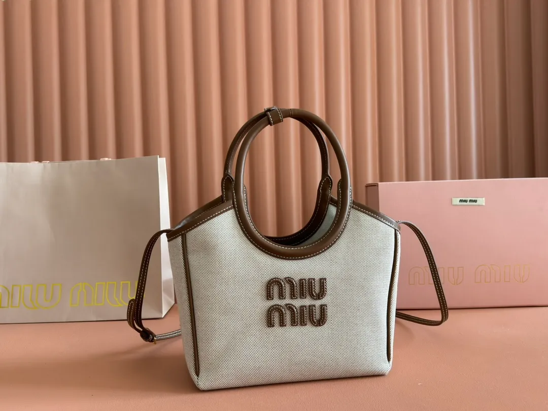 p1360. 💋💋💋【Full set of packaging at the counter】Miu's new product Isetan limited edition tote bag, promoted by the official website, absolutely popular this year🔥 style, top imported calfskin, the leather surface is delicate, smooth and soft, the superior leather texture is high-end, the bag body is soft but not collapsed, small size The design is more refined, and the temperament is casual and lazy. It will turn heads every day when you carry it on the street. It has hand-stitched leather logo, brand new linen lining, two zippered pockets, long adjustable leather shoulder strap, model 5BA288, size 22X 14X11Cm.