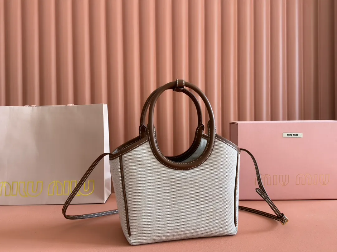 p1360. 💋💋💋【Full set of packaging at the counter】Miu's new product Isetan limited edition tote bag, promoted by the official website, absolutely popular this year🔥 style, top imported calfskin, the leather surface is delicate, smooth and soft, the superior leather texture is high-end, the bag body is soft but not collapsed, small size The design is more refined, and the temperament is casual and lazy. It will turn heads every day when you carry it on the street. It has hand-stitched leather logo, brand new linen lining, two zippered pockets, long adjustable leather shoulder strap, model 5BA288, size 22X 14X11Cm.