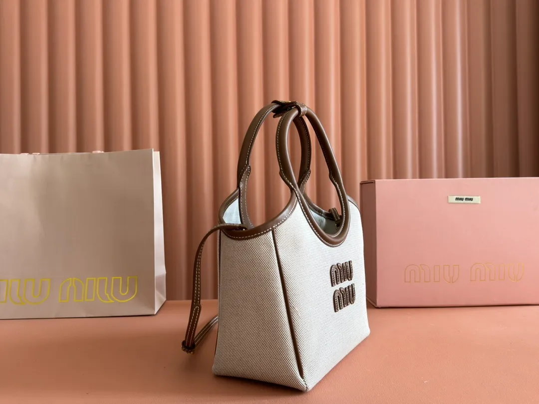 p1360. 💋💋💋【Full set of packaging at the counter】Miu's new product Isetan limited edition tote bag, promoted by the official website, absolutely popular this year🔥 style, top imported calfskin, the leather surface is delicate, smooth and soft, the superior leather texture is high-end, the bag body is soft but not collapsed, small size The design is more refined, and the temperament is casual and lazy. It will turn heads every day when you carry it on the street. It has hand-stitched leather logo, brand new linen lining, two zippered pockets, long adjustable leather shoulder strap, model 5BA288, size 22X 14X11Cm.